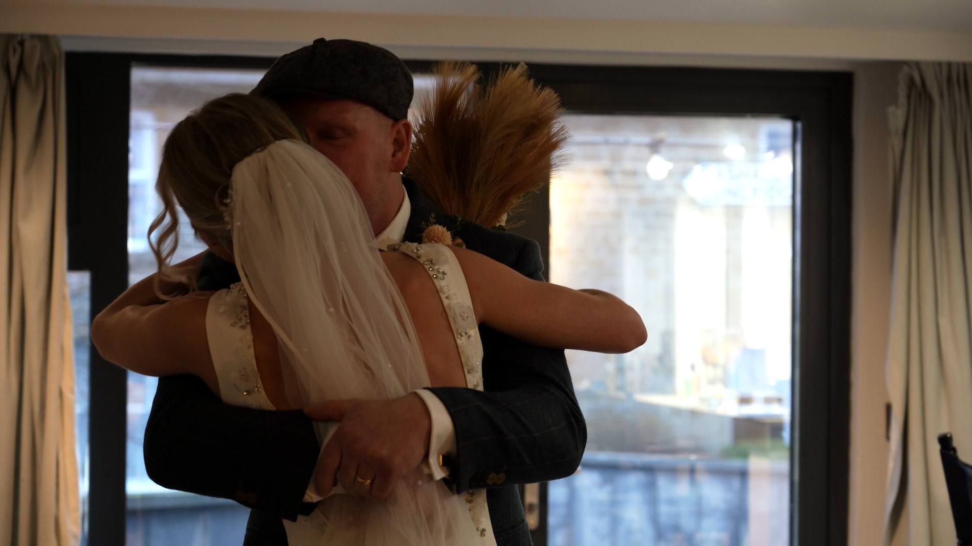 video still of dad giving his daughter a hug on the morning of her wedding