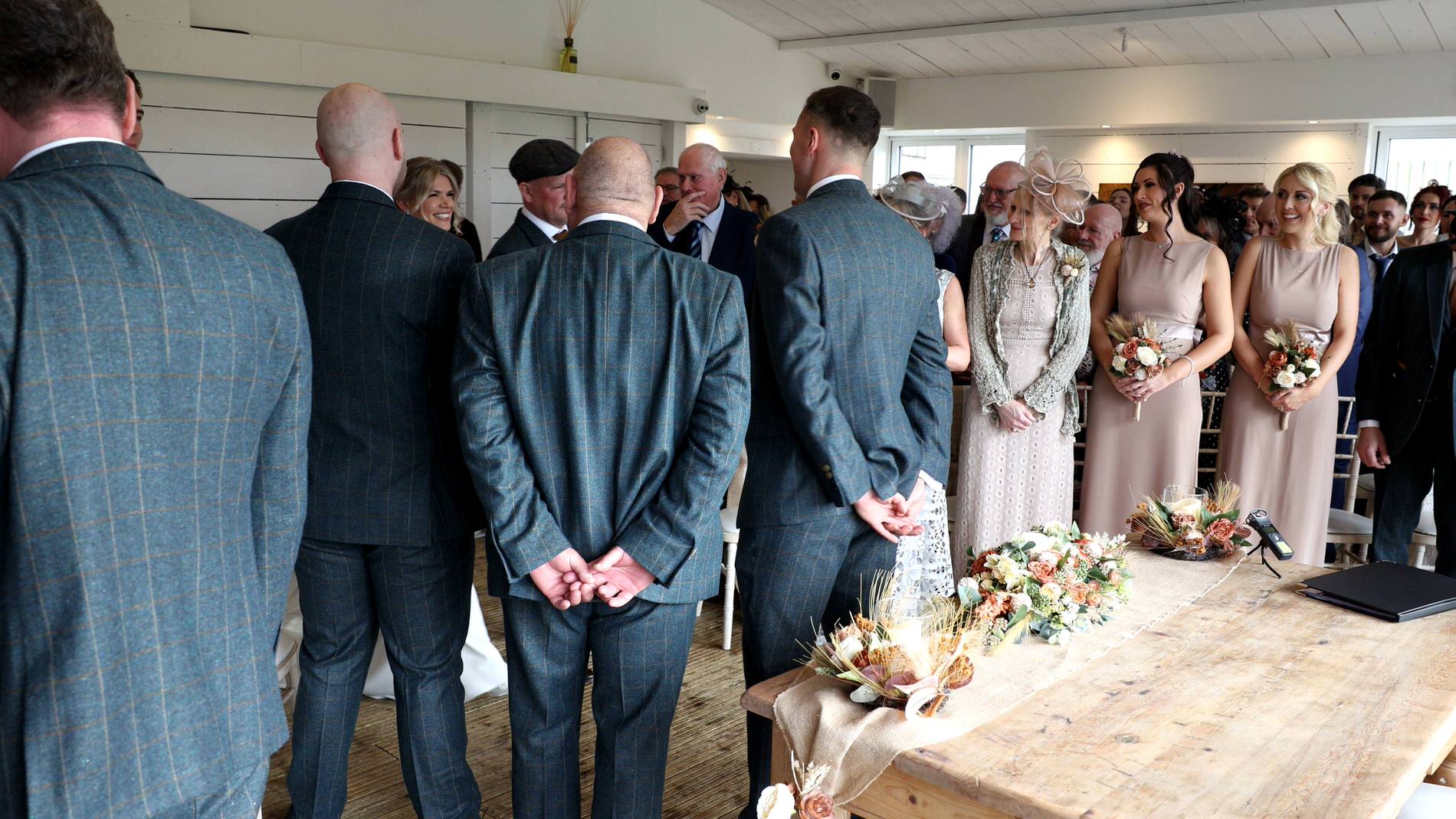 a wide video still of bride walking down the aisle