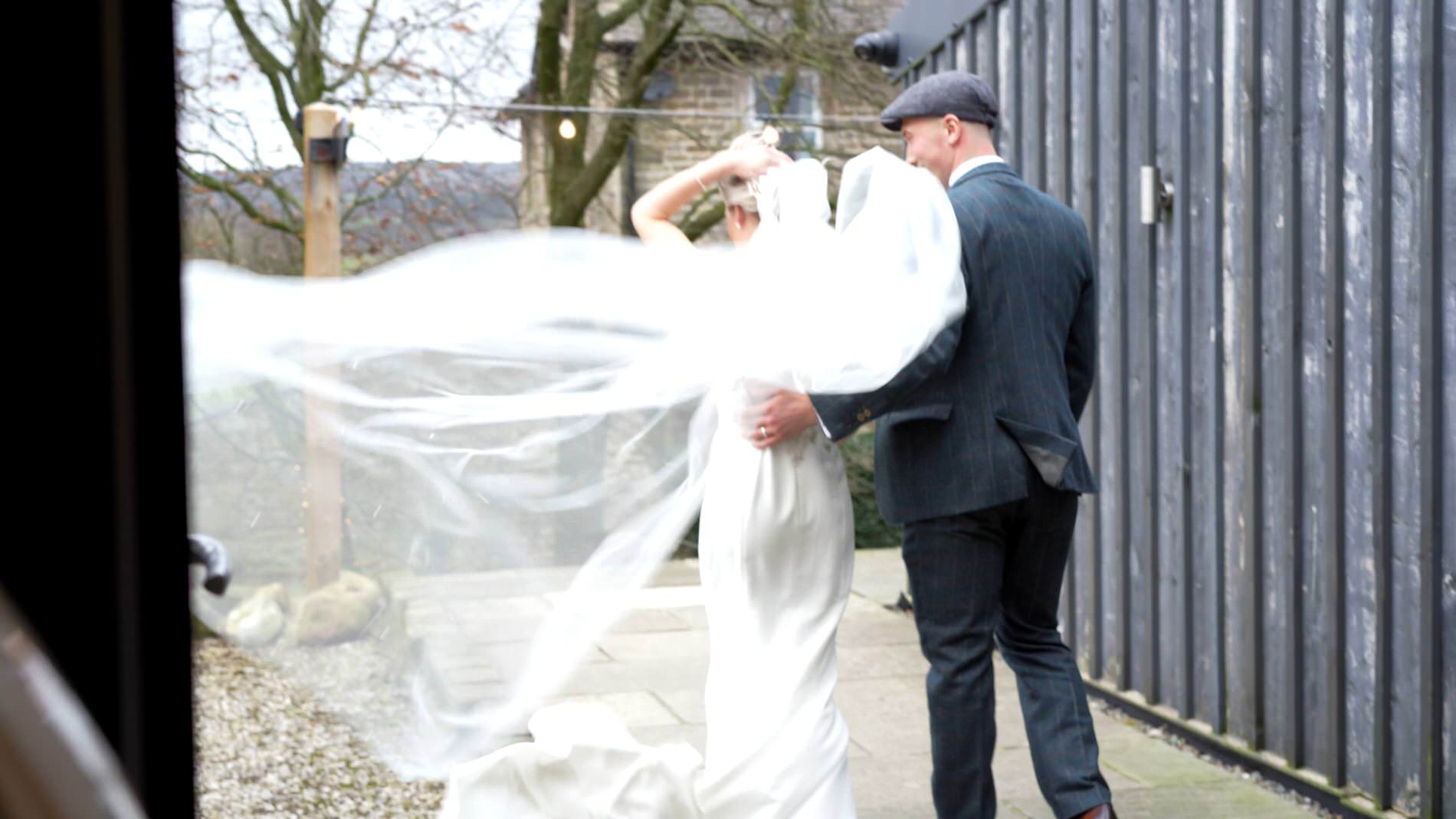 a unique video still of a very windy cathedral length veil outside Bashall