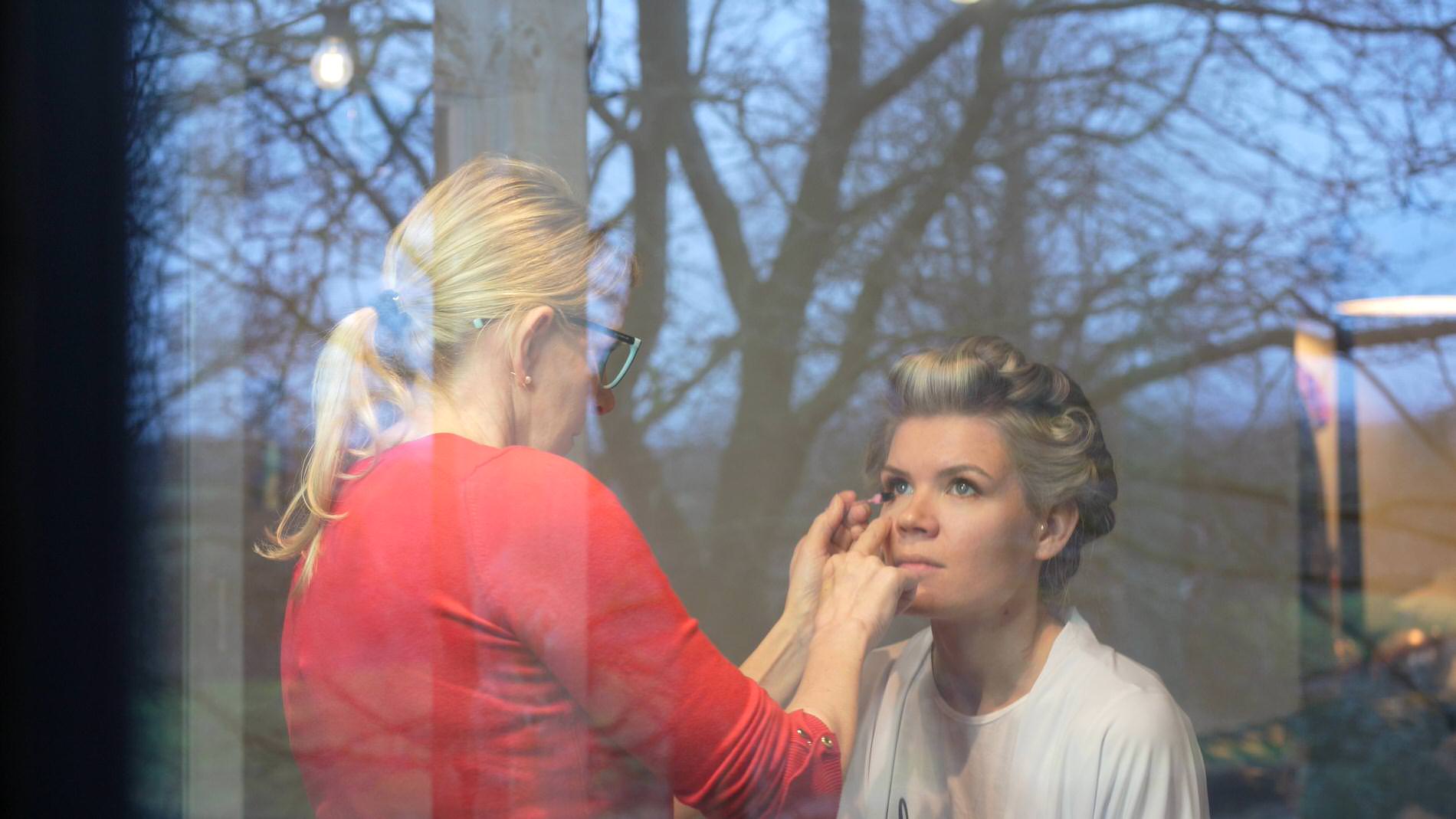 video still of a bride getting ready at Bashall Barn in the window reflection