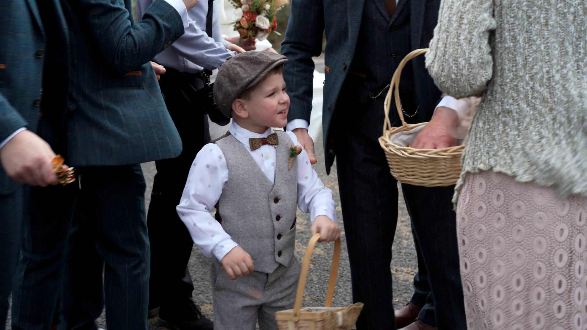 a page boy tries to give out confetti in the wind