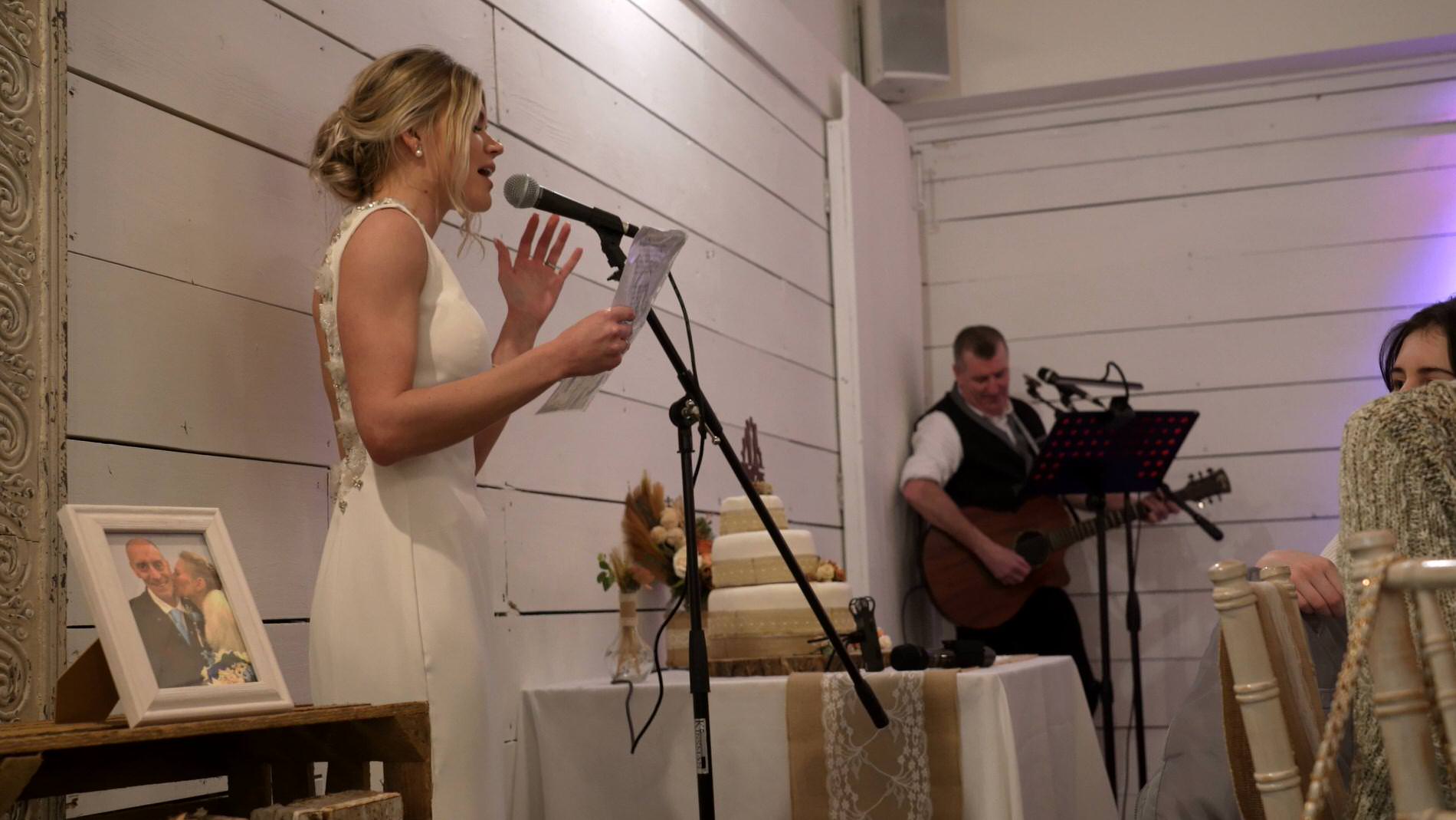 the bride sings as a surprise during the wedding reception at Bashall Barn