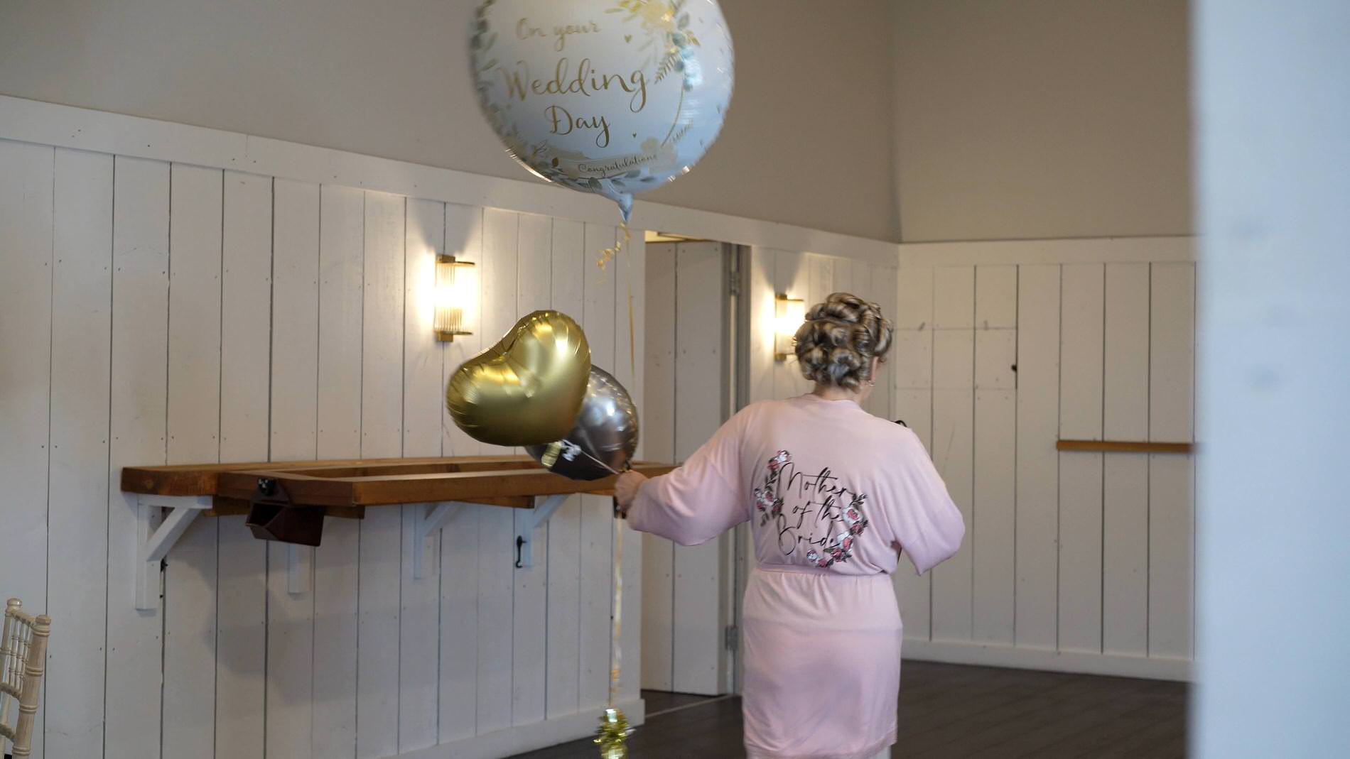 a mother of the bride arrives with a wedding balloon