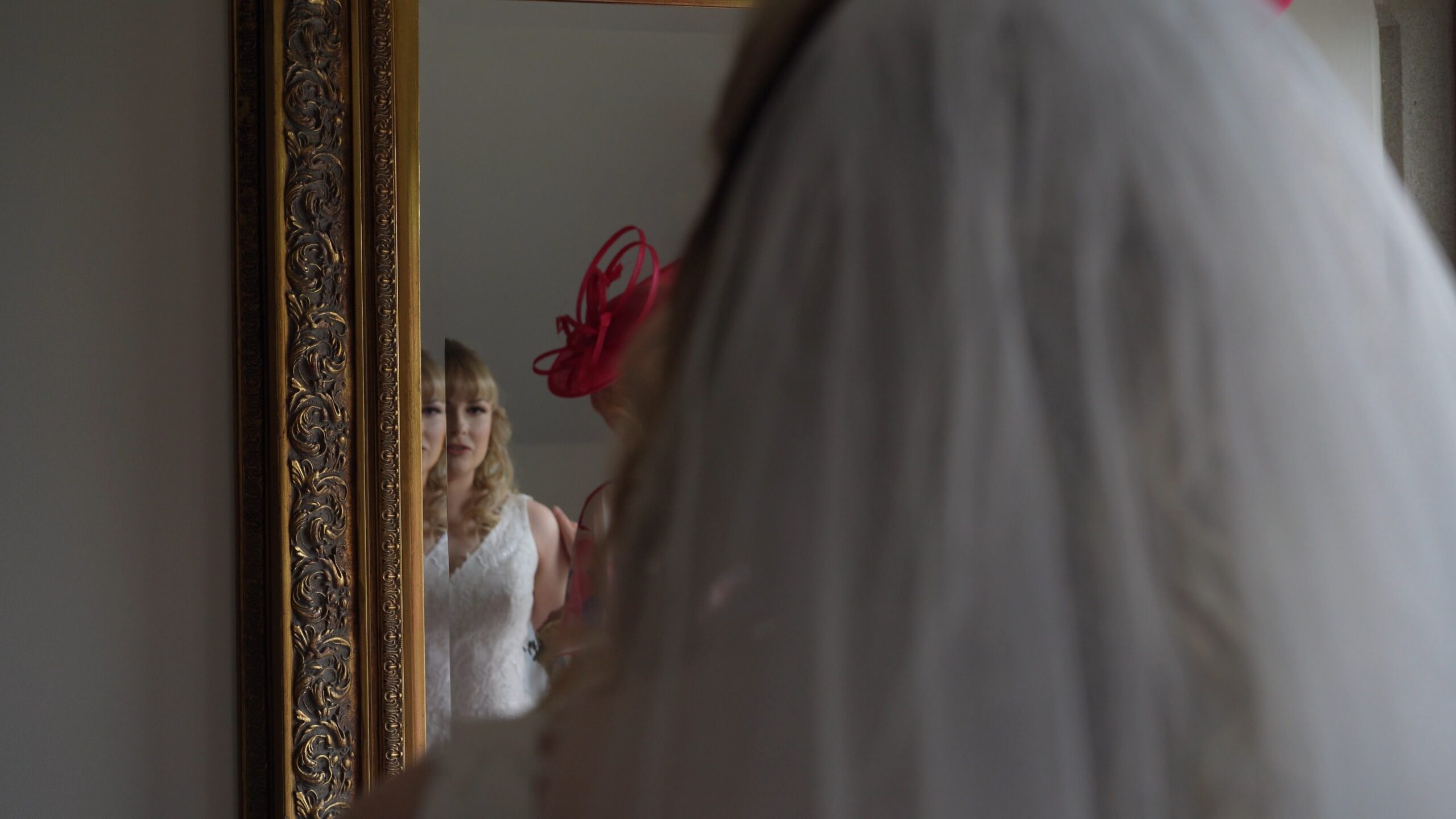 a shot over the brides shoulder to see her reflection in a mirror