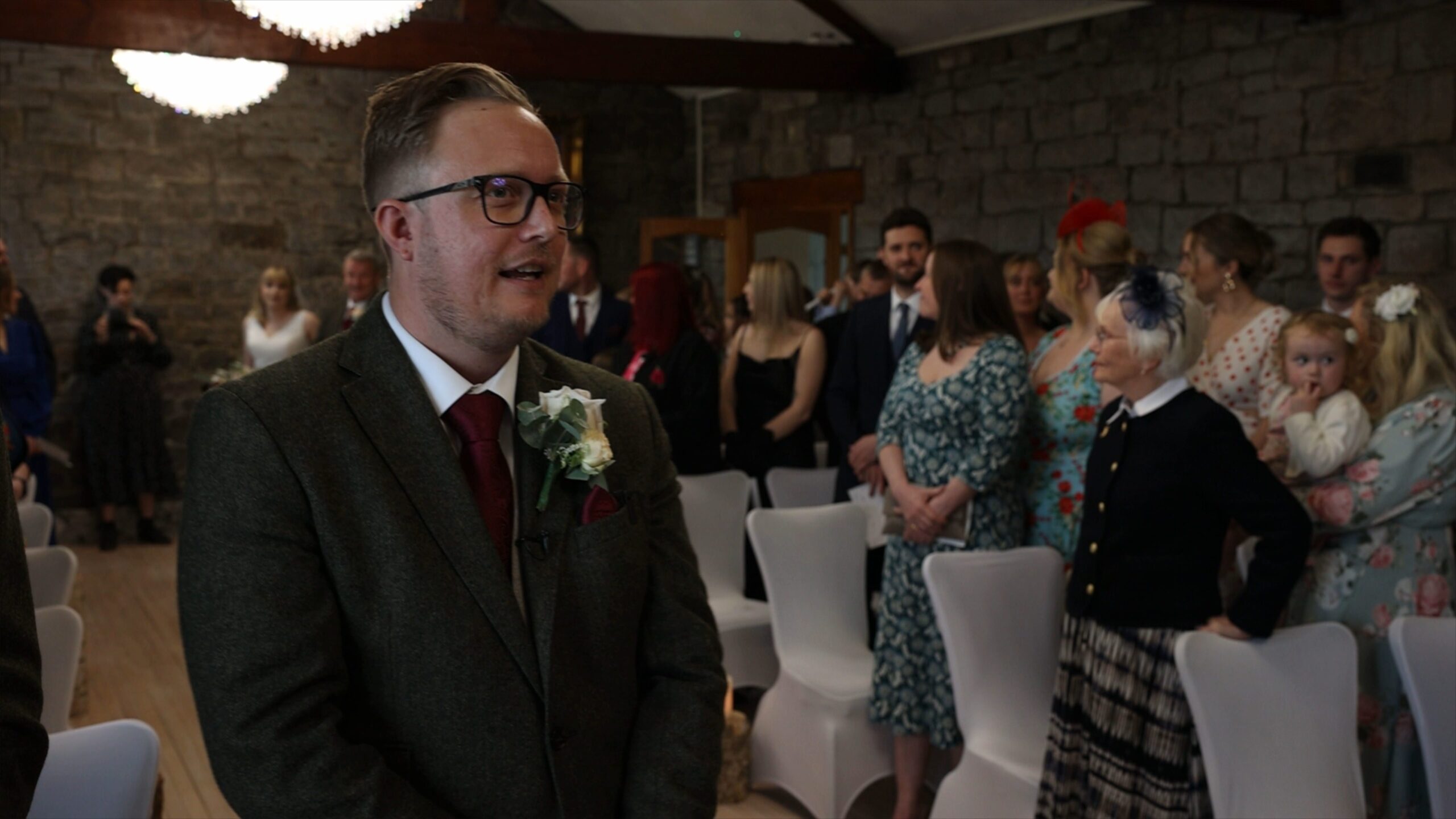 the groom takes a breath as he sees his bride in the reflection during the ceremony