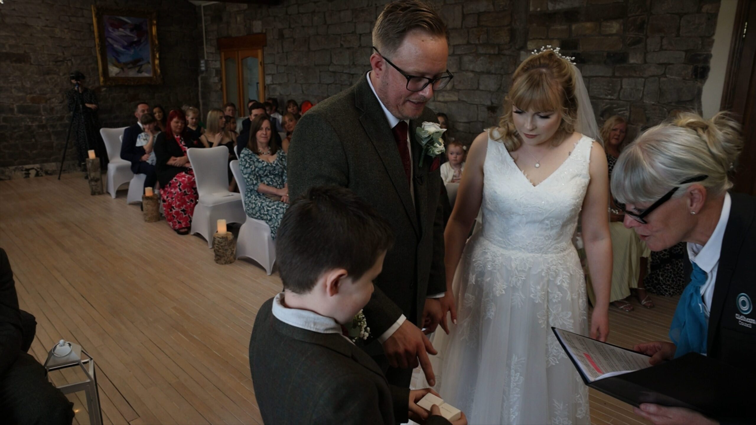 a young ring barer hands over the wedding rings