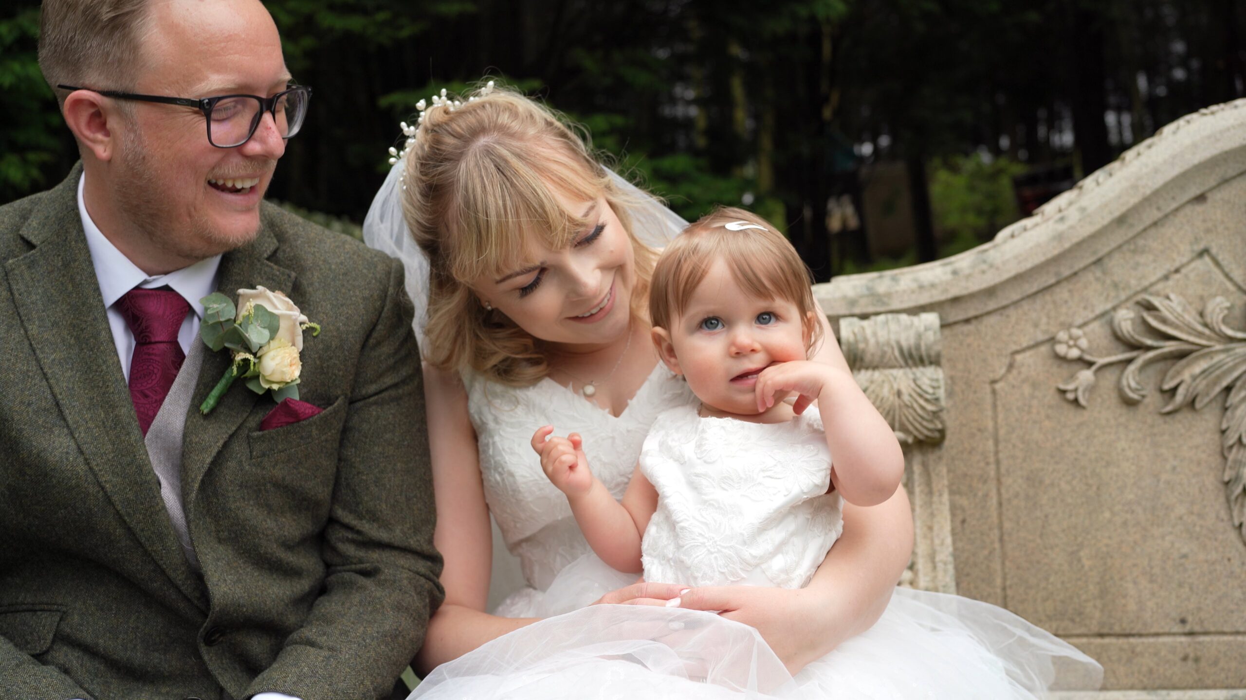 a close up video still of the couple smiling at their daughter