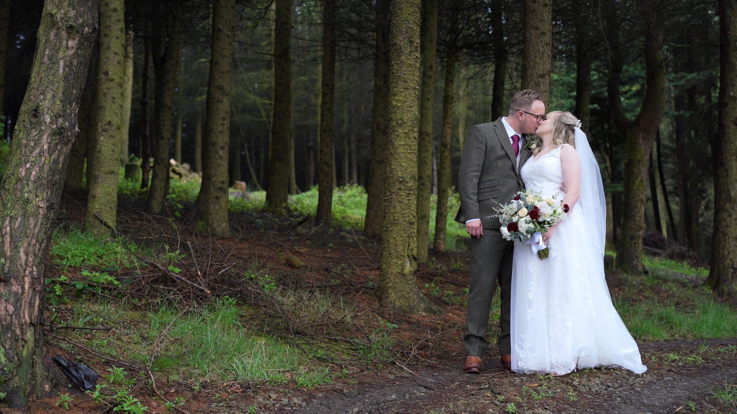 the couple pose in the woods outside The Saddleworth Hotel