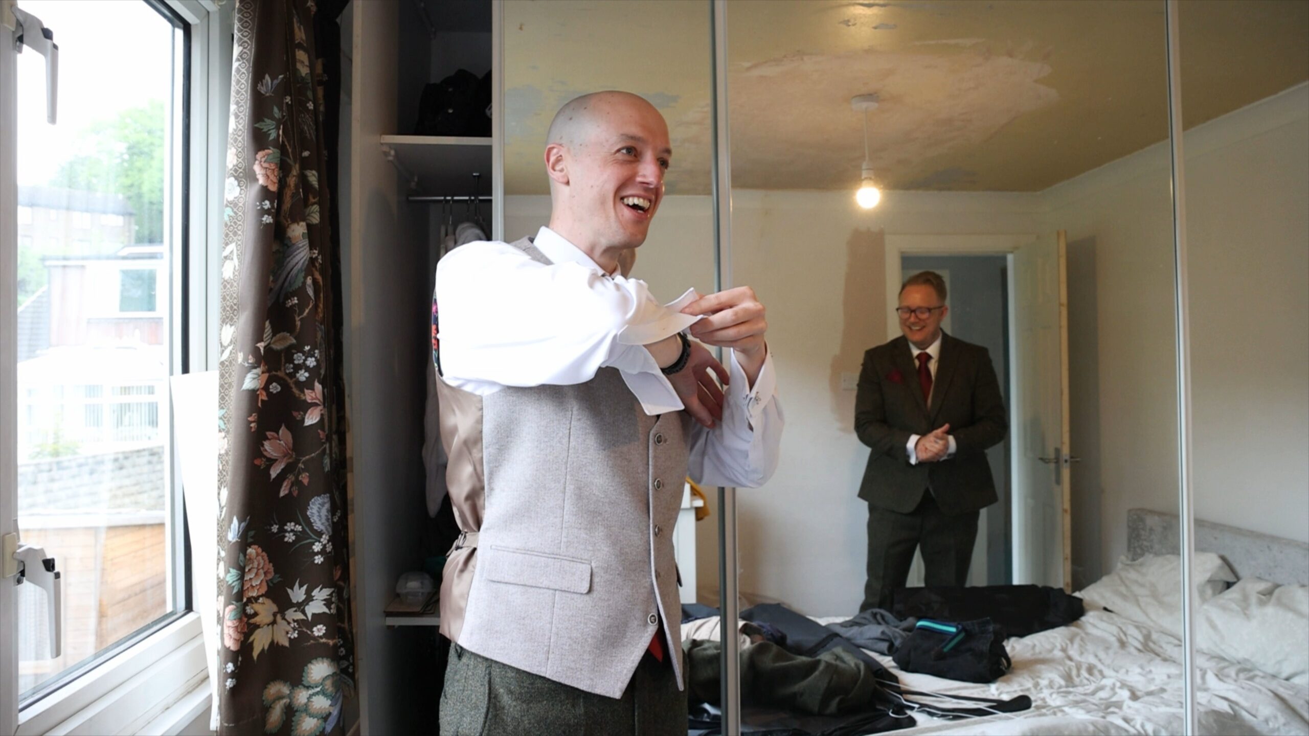 a best man laughs with the groom whilst getting ready in Halifax