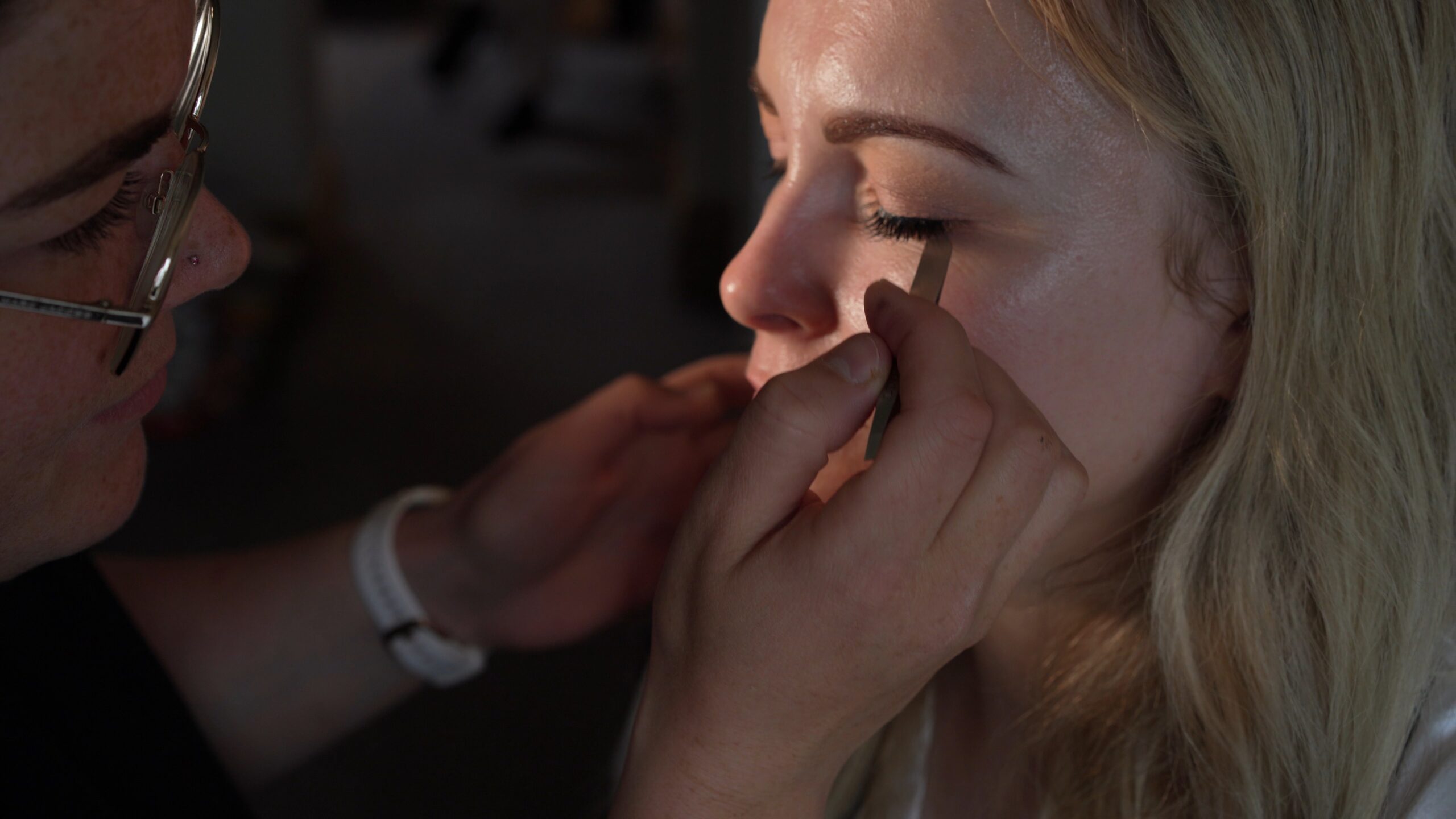 a close up shot of a bride getting her eye makeup done