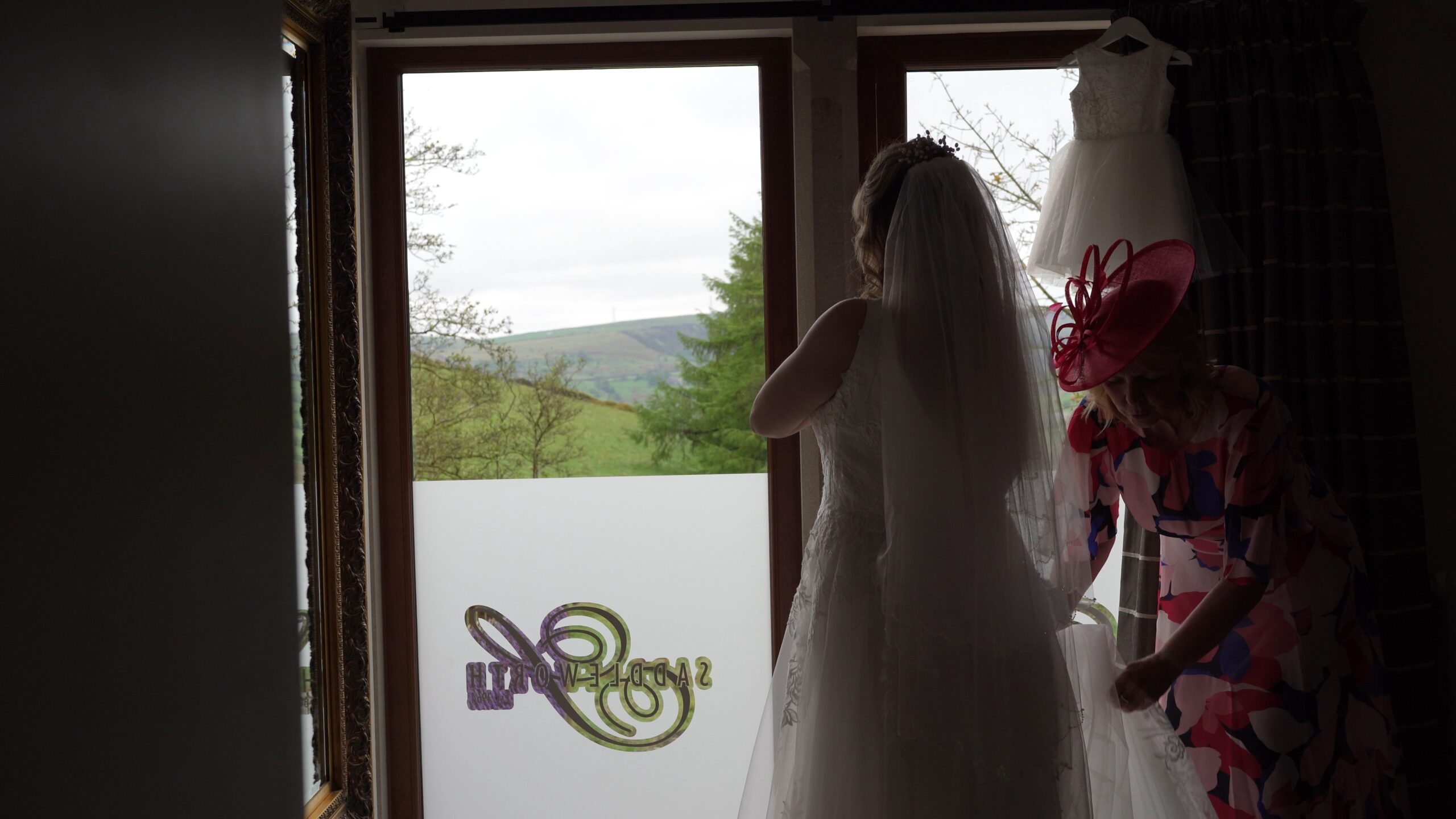 a bride gets ready with her mum in natural light at The Saddleworth Hotel