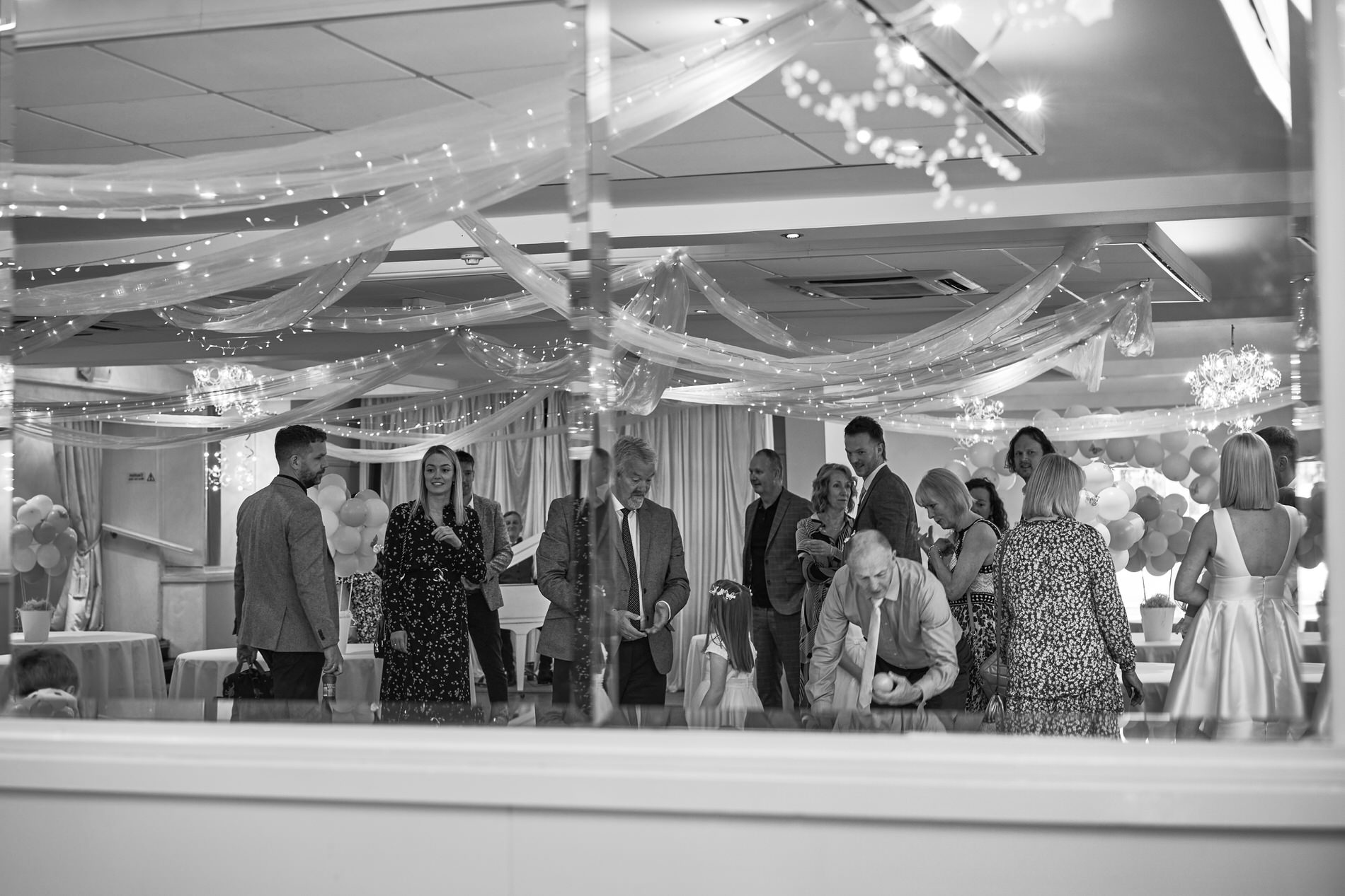 a candid photo through a mirror of guests arriving for a naming day at holland hall