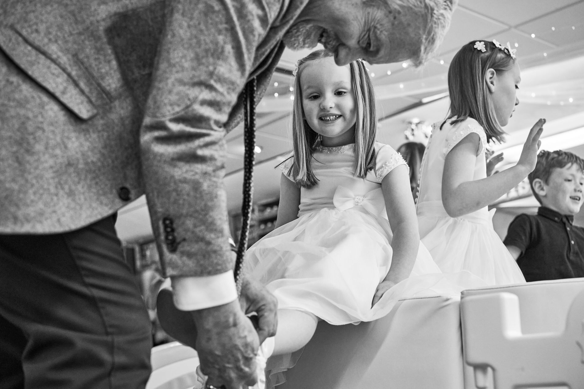 a little girl gets her shoes back on after playing