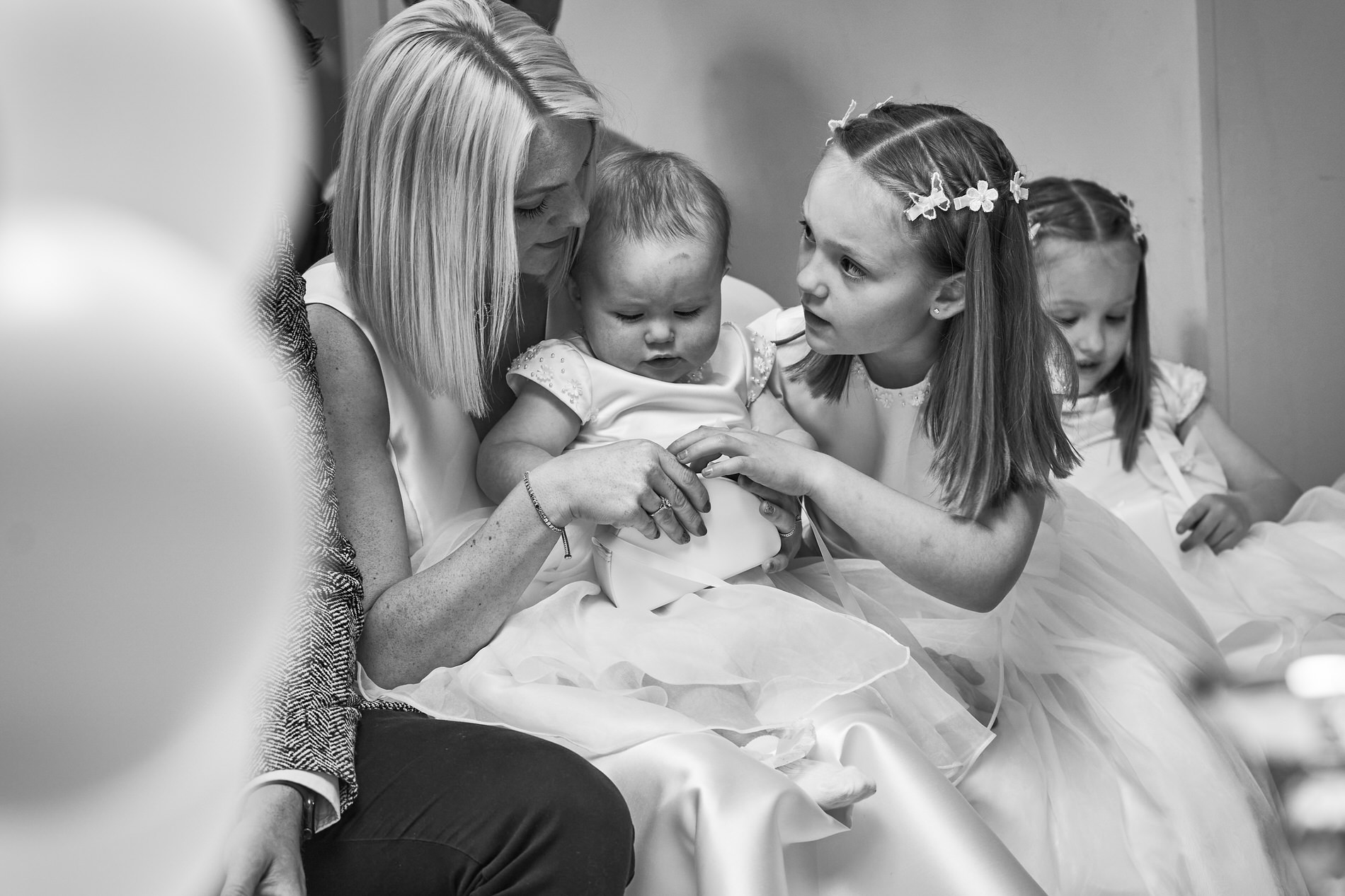 a big sister tends to her baby sister during her naming day at holland hall