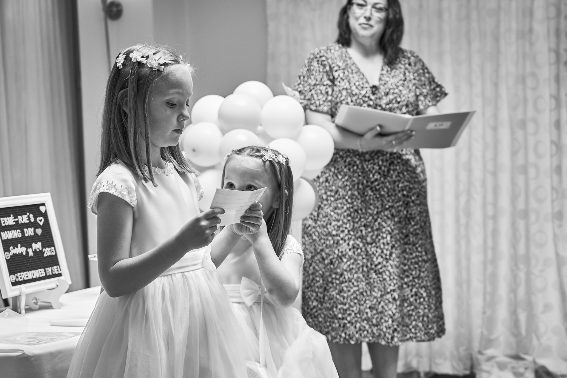 big sisters read their promises to their baby sister during a personal naming day at Holland Hall