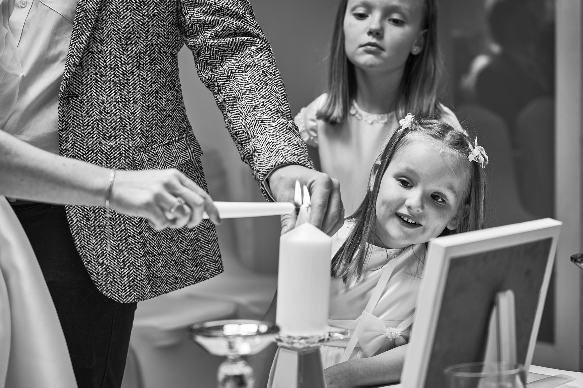 a candid photo of a little girl looking curiously at the naming day candle