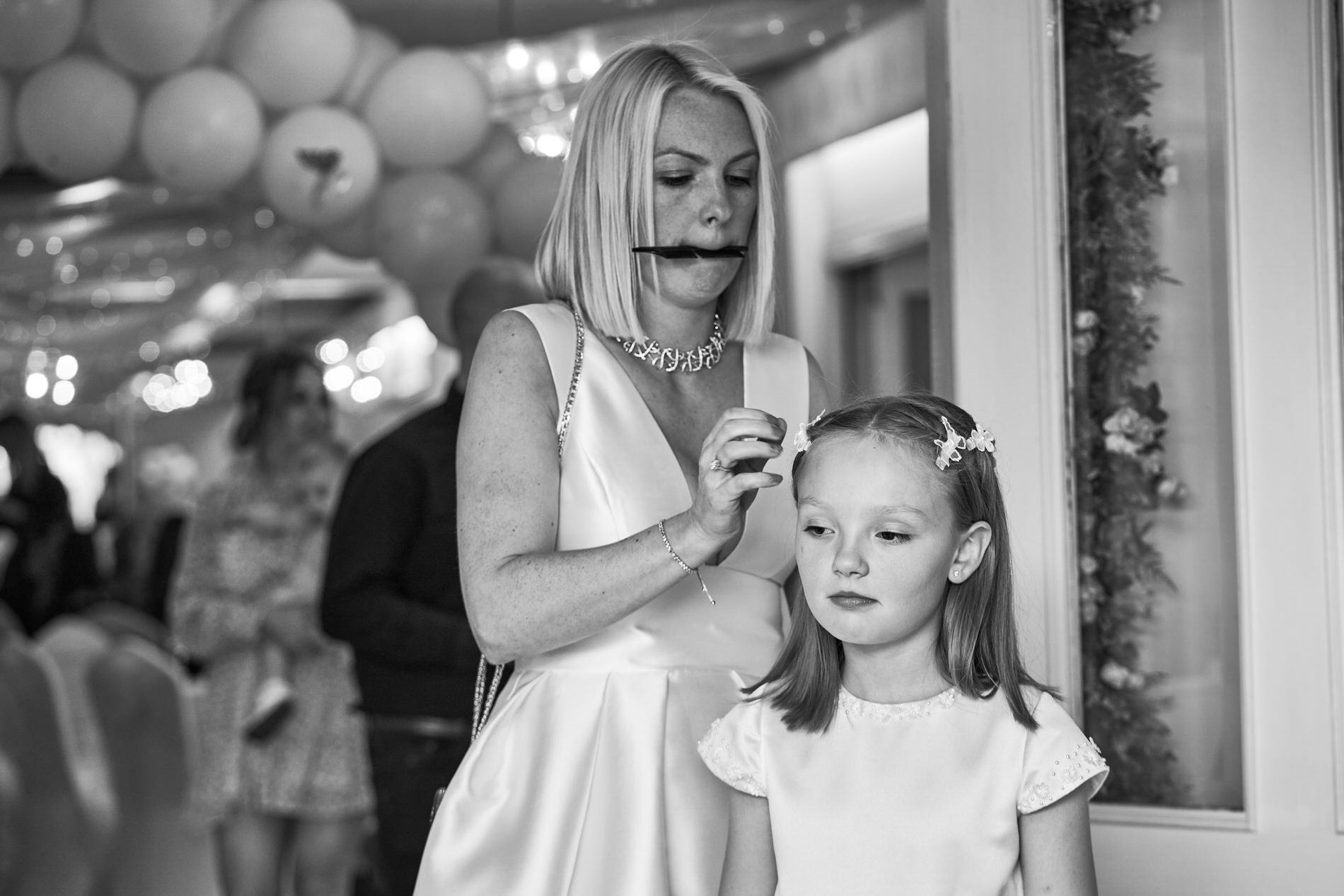 a candid real life photo of Mum sorting out her daughters hair