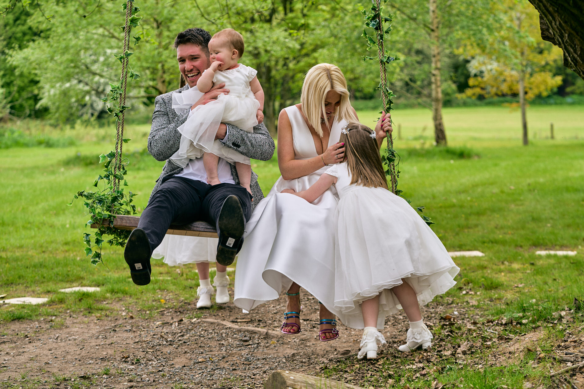 a family play on a swing by a tree after their Naming Day at Holland Hall