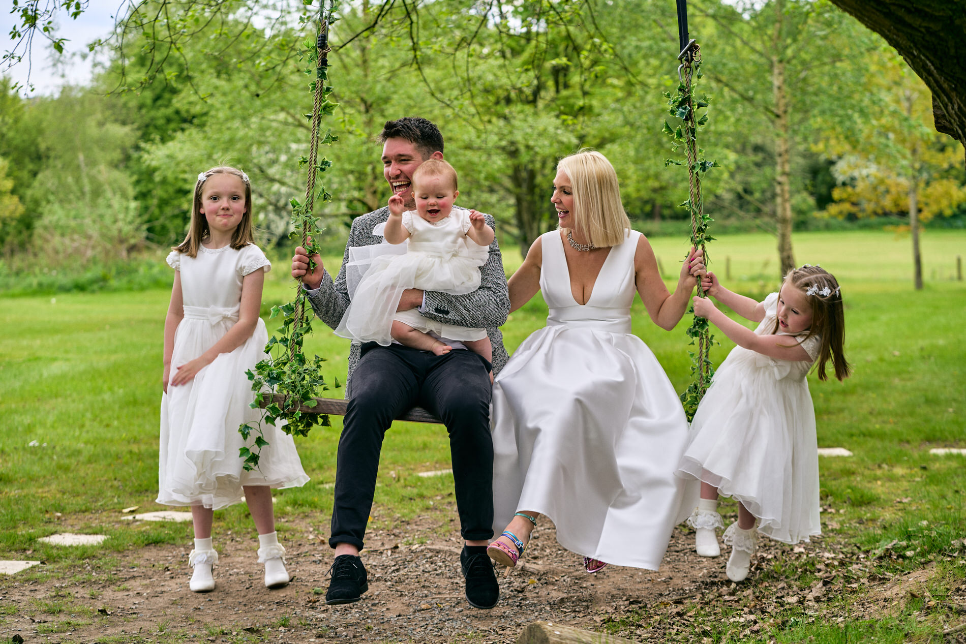 a family laugh as they swing in the gardens at Holland Hall Lancashire