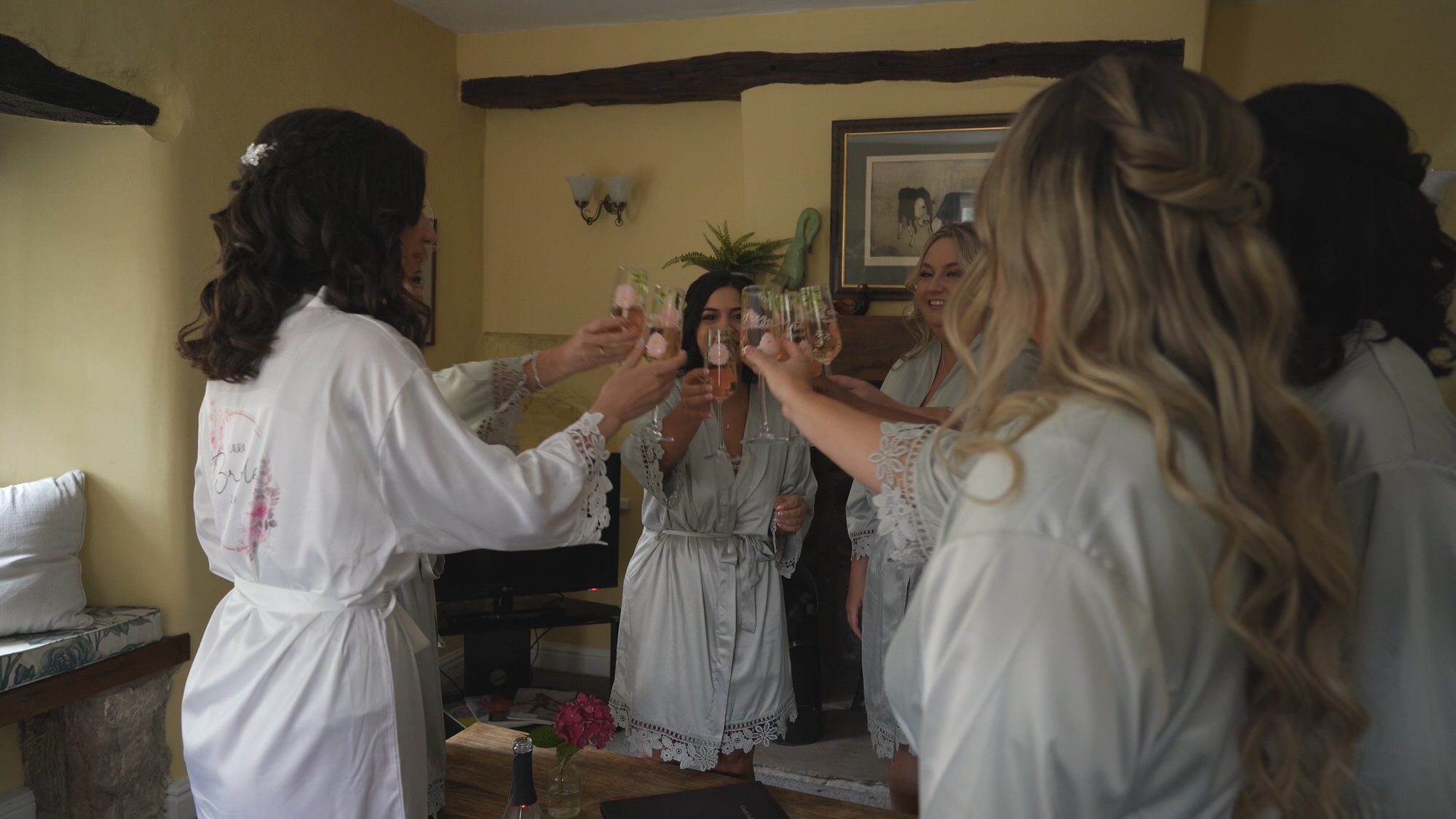 a bride and her bridesmaids cheers hand drawn glasses at Browsholme