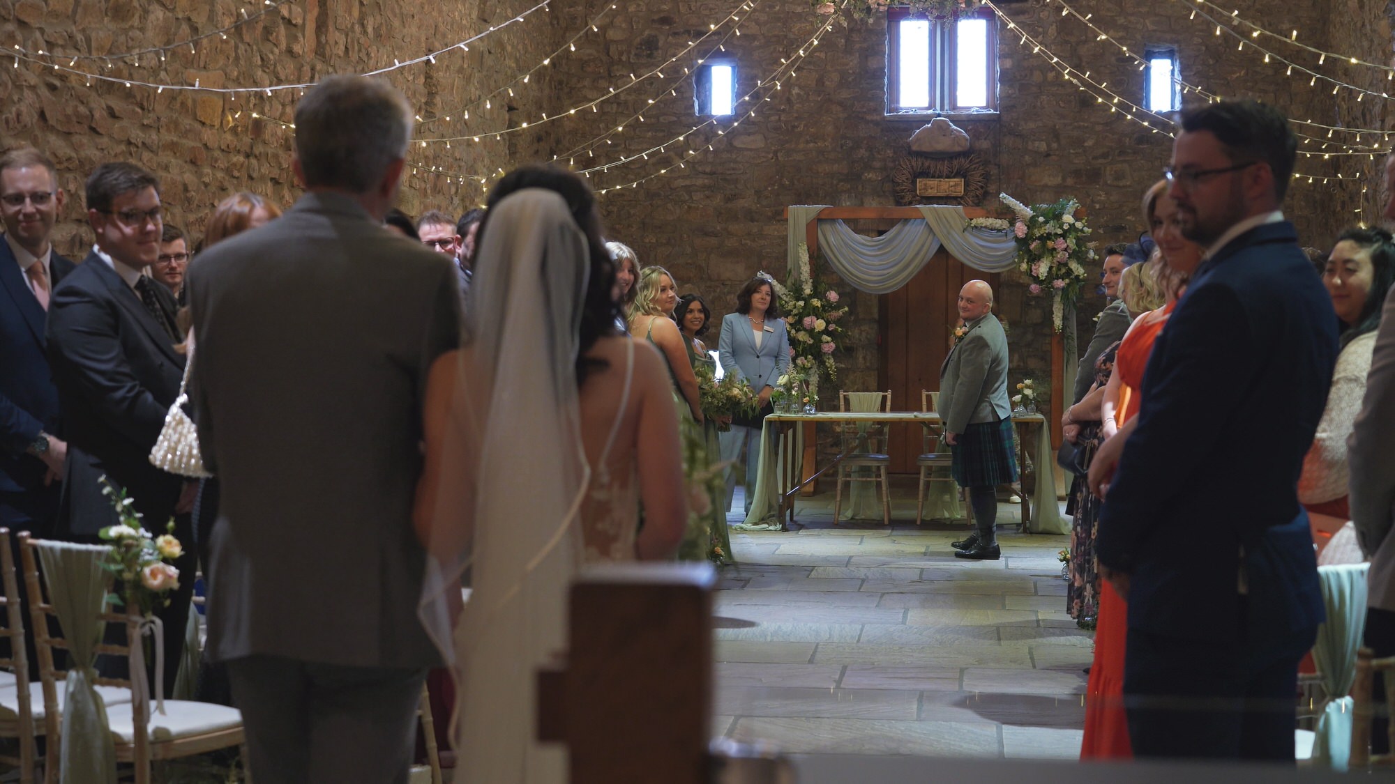 a bride walks towards her groom at Browsholme Hall Tithe BarnLancashire