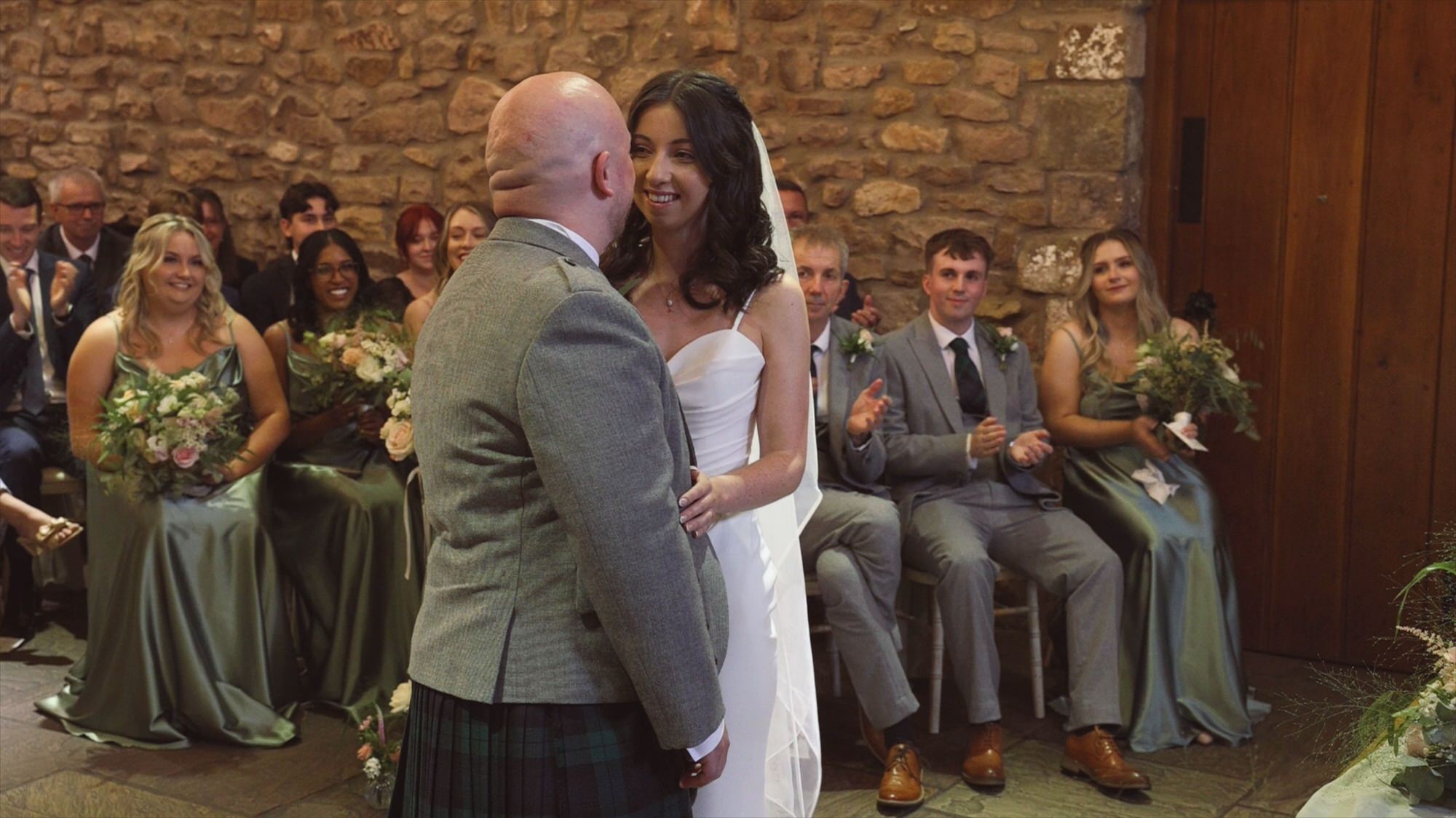 a couple smile at each other after their first kiss as husband and wife