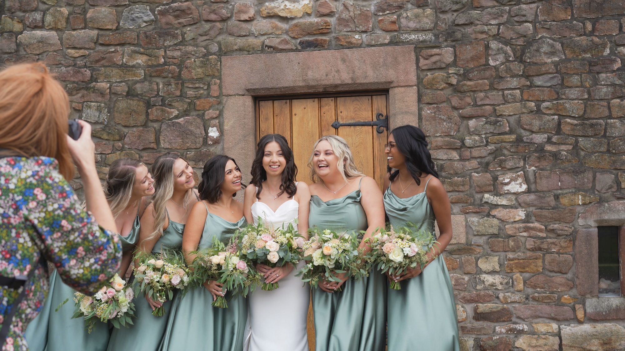 a videographer films Jules Fortune Photography posing bridesmaids outside Browsholme Hall