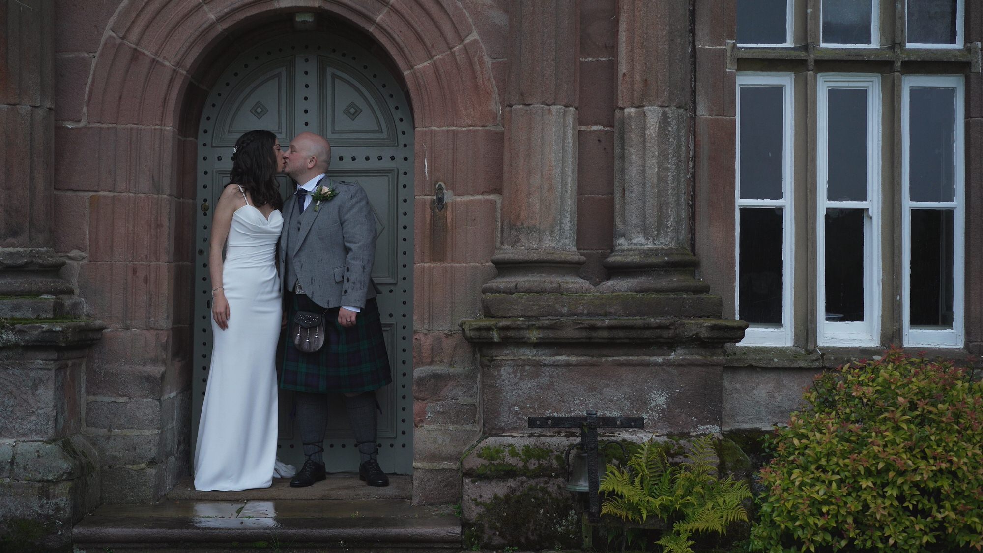 a couple stand in a wet doorway outside Browsholme Hall Lancashire