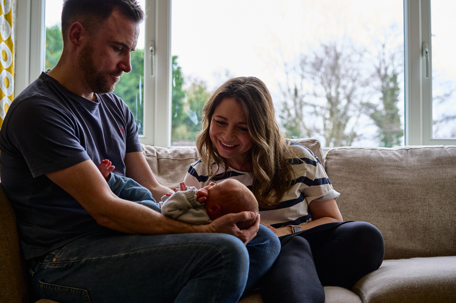 mum and dad gaze down at baby for photographer in Burscough