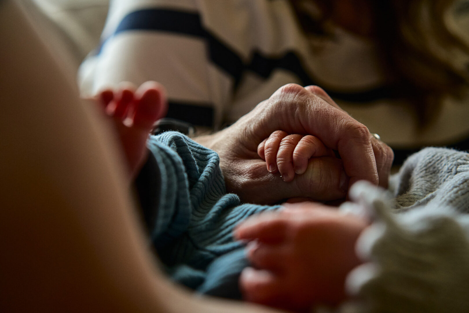 a close up photography of a baby holding dads finger
