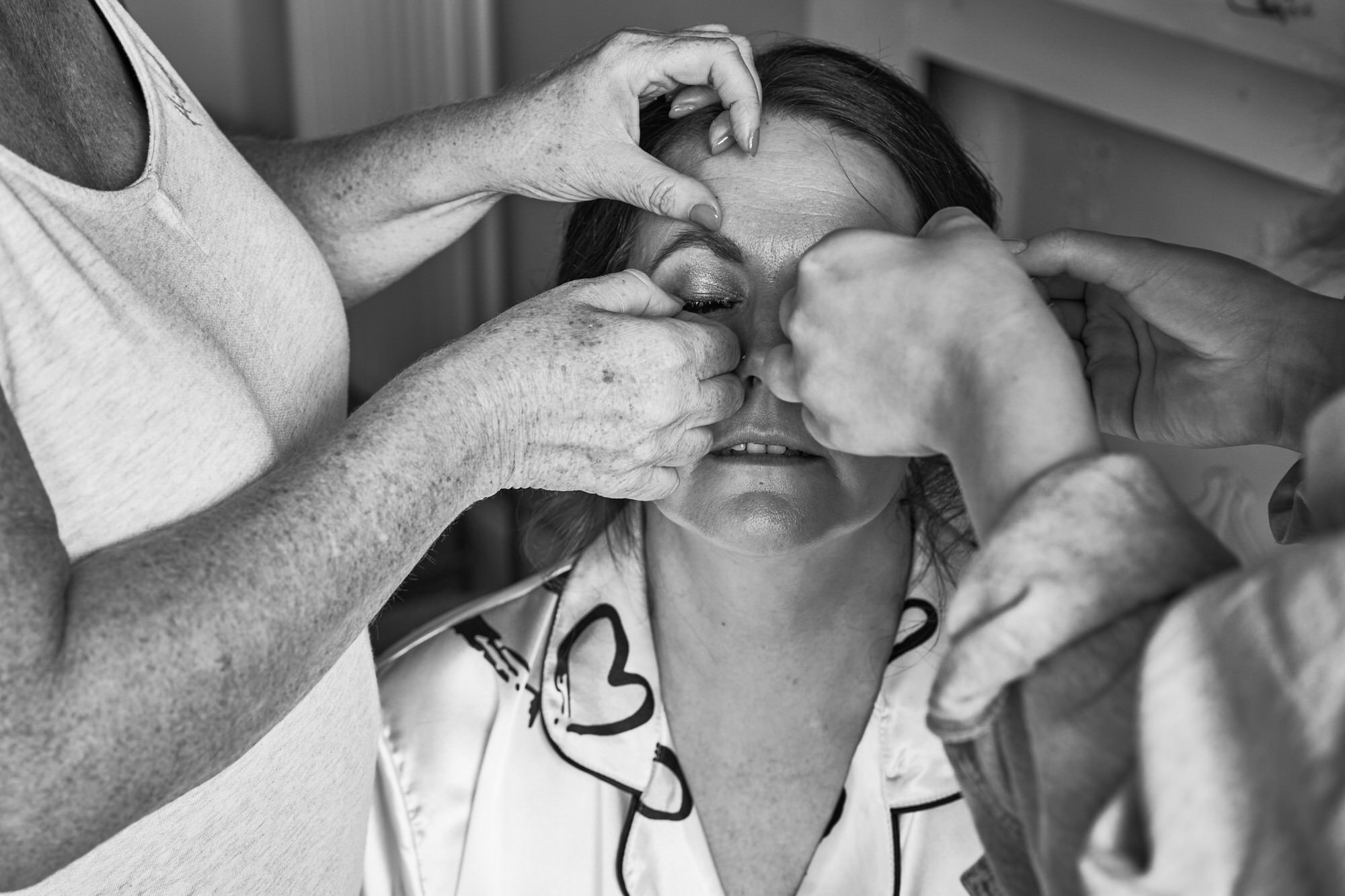 a close up photo of a bride having her eyelashes glued