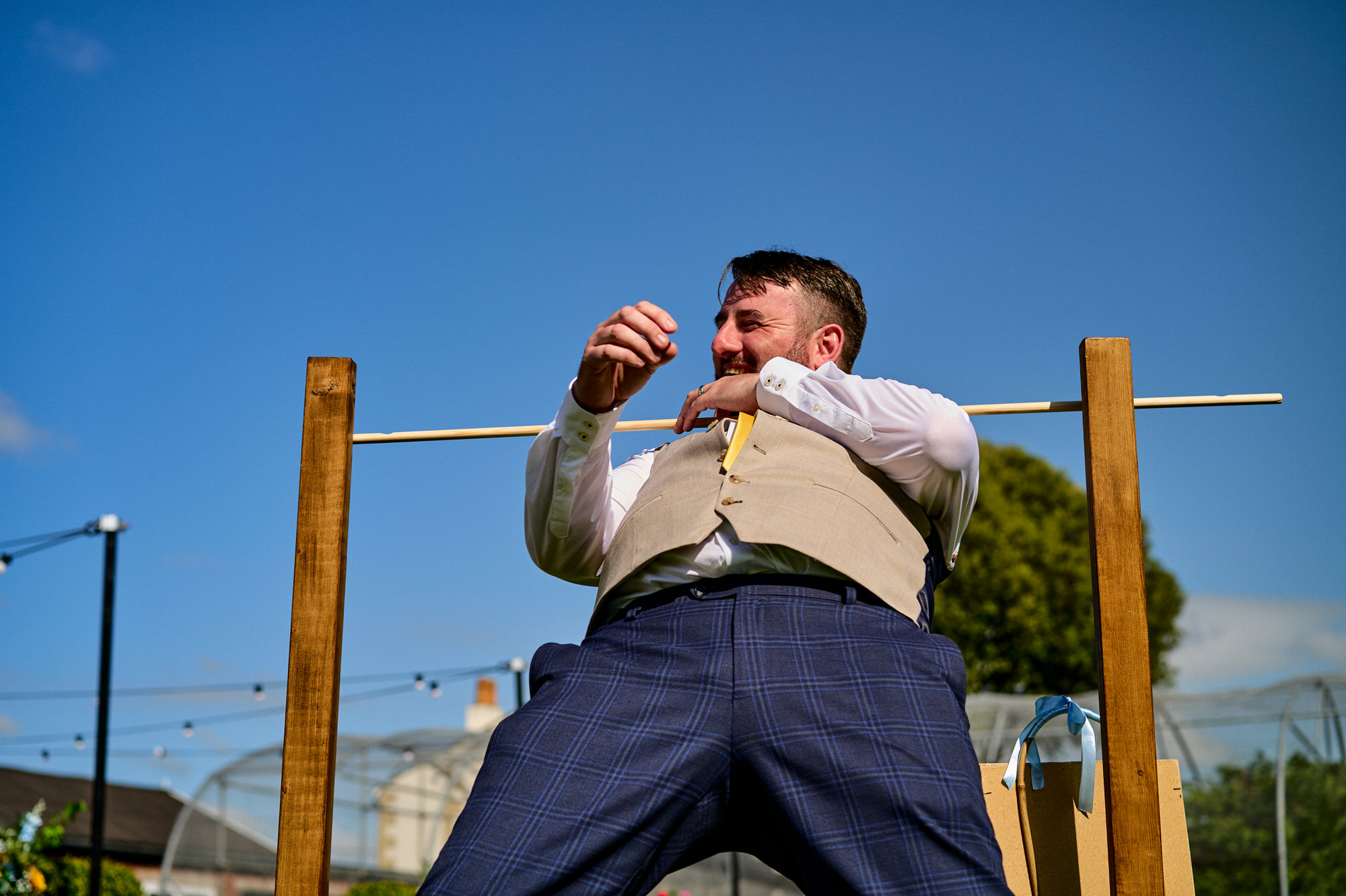 a groom laughs as he gets stuck in limbo at The Aviary Ormskirk
