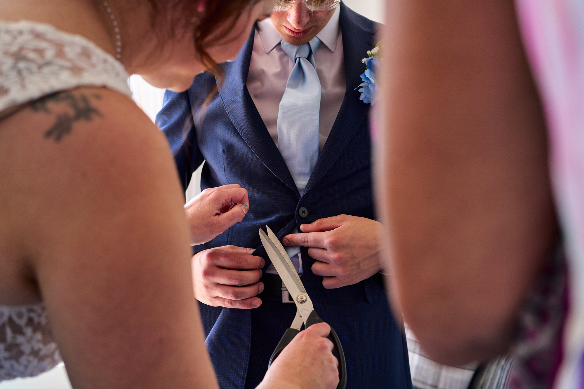 a unique perspective photo of a thread being cut on a suit