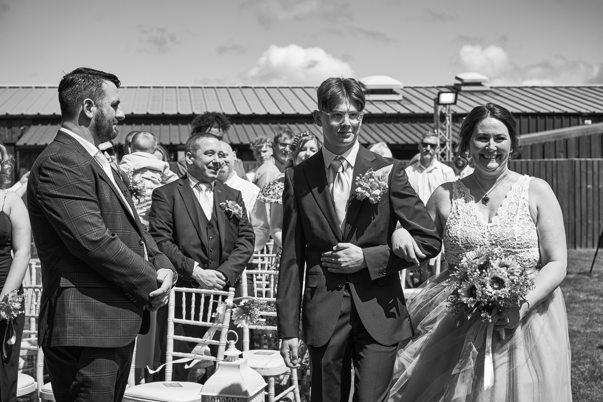a bride walks down the aisle during an outdoor ceremony at The Aviary Ormskirk