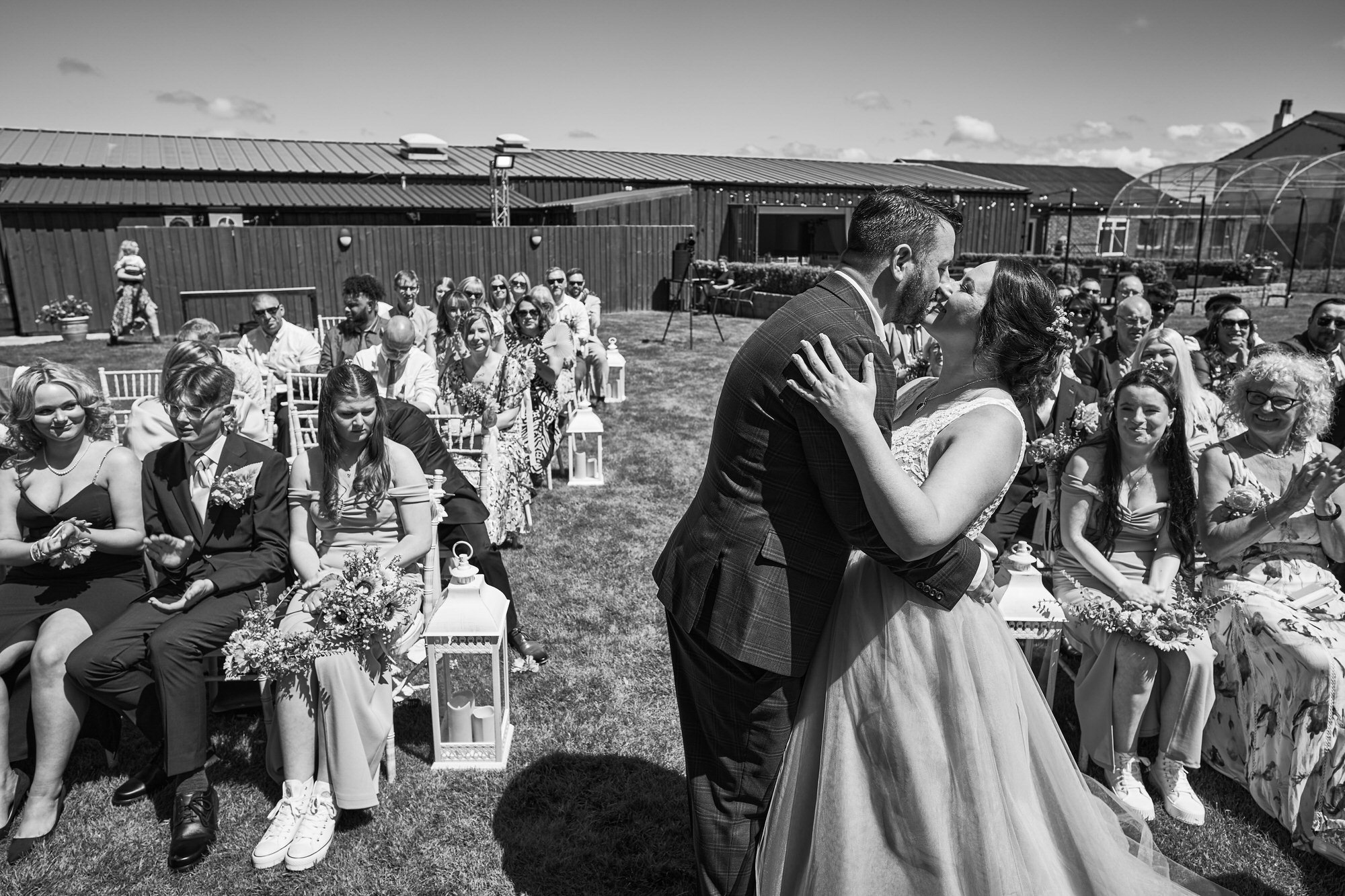 a white black and white photo of the first kiss during outdoor ceremony at The Aviary Ormskirk