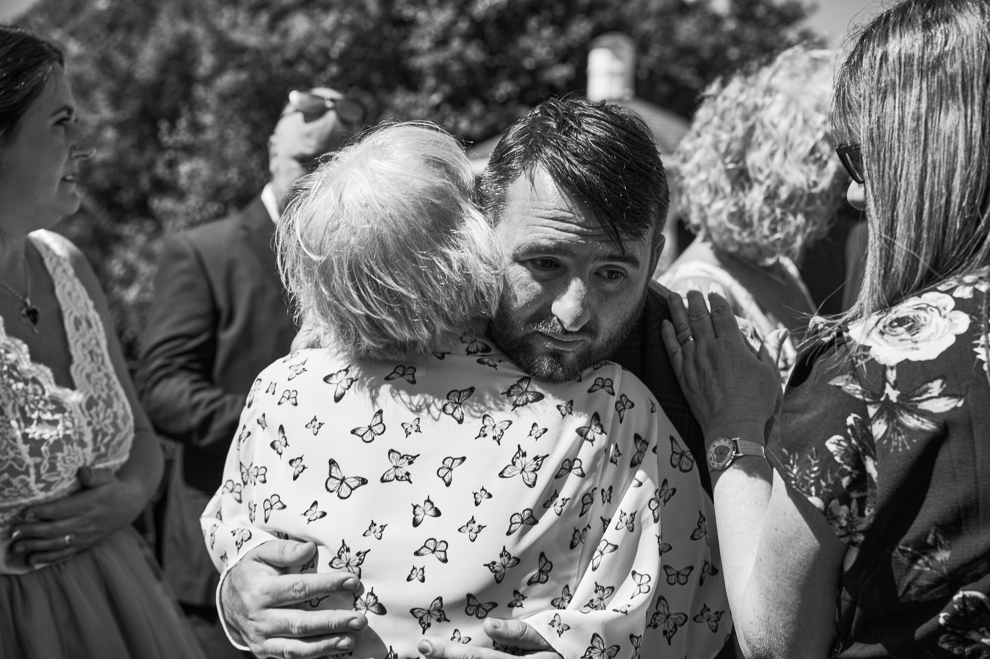 a groom hugs an elderly guest