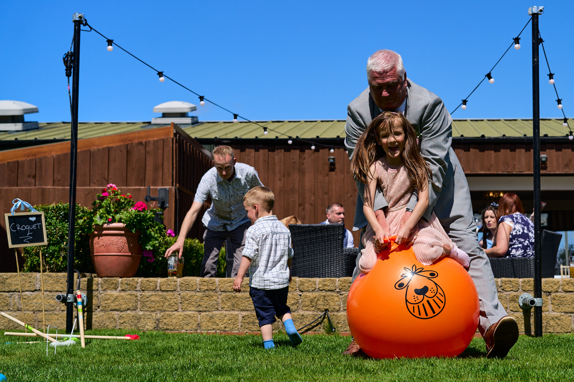 kids and an older guest enjoy the space hoppers at a wedding