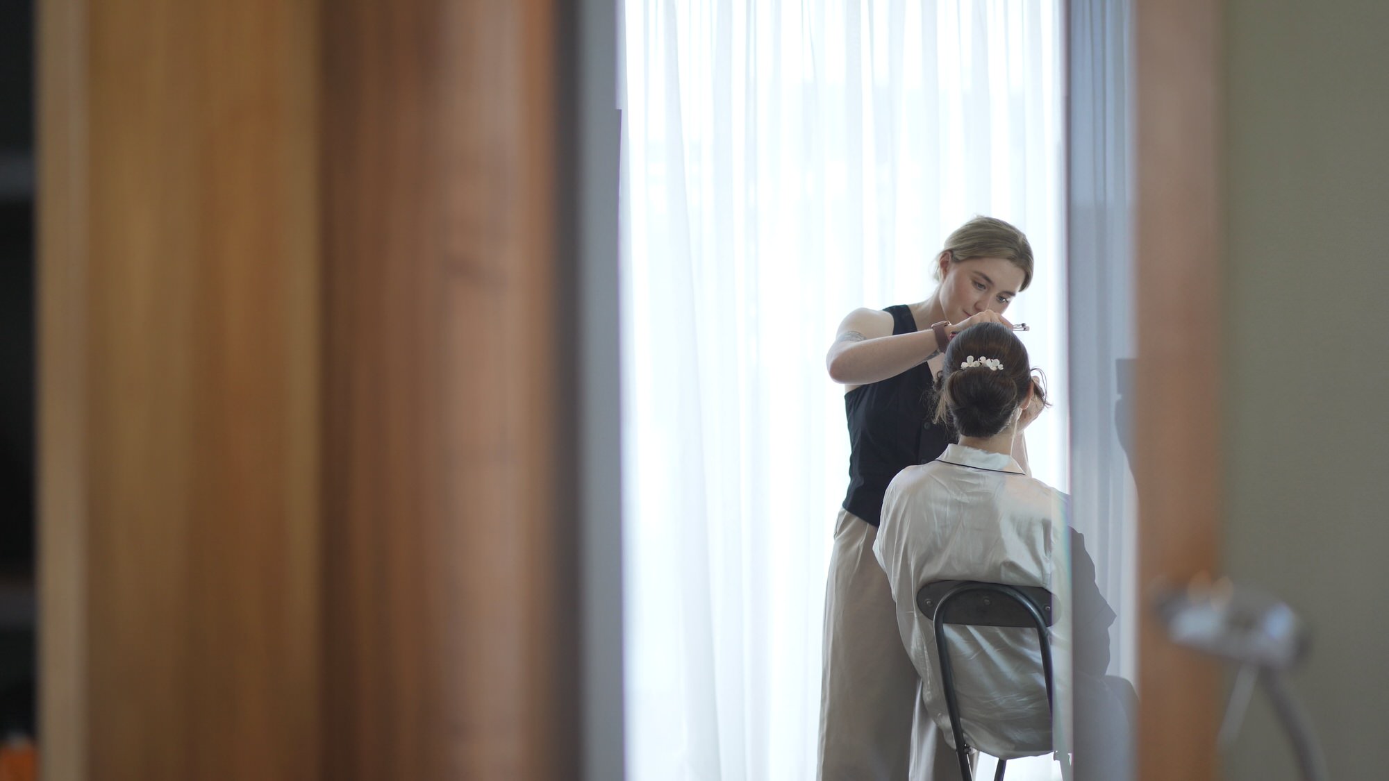 a bride sits with her makeup artist in a suite at Hilton Liverpool