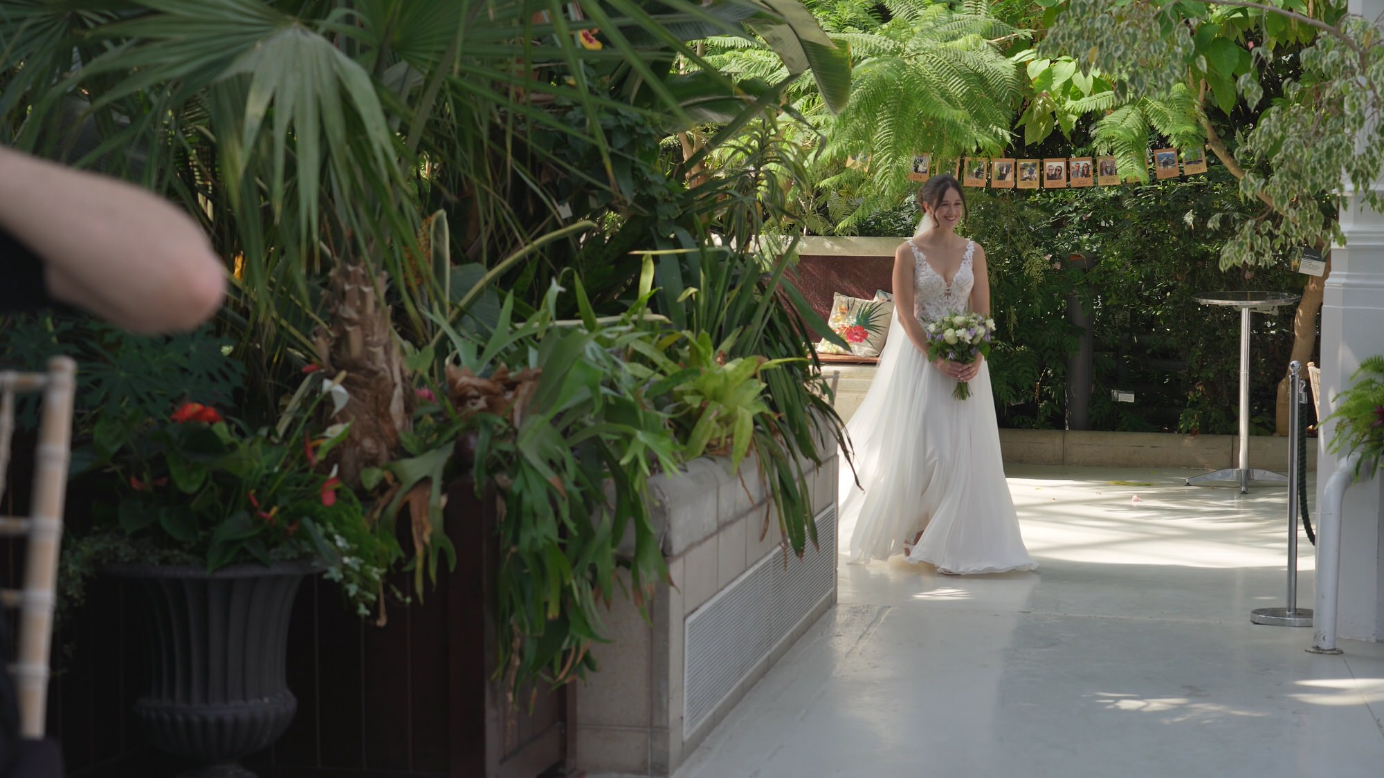 a bride makes her solo walk down the aisle at Sefton Park Palm House