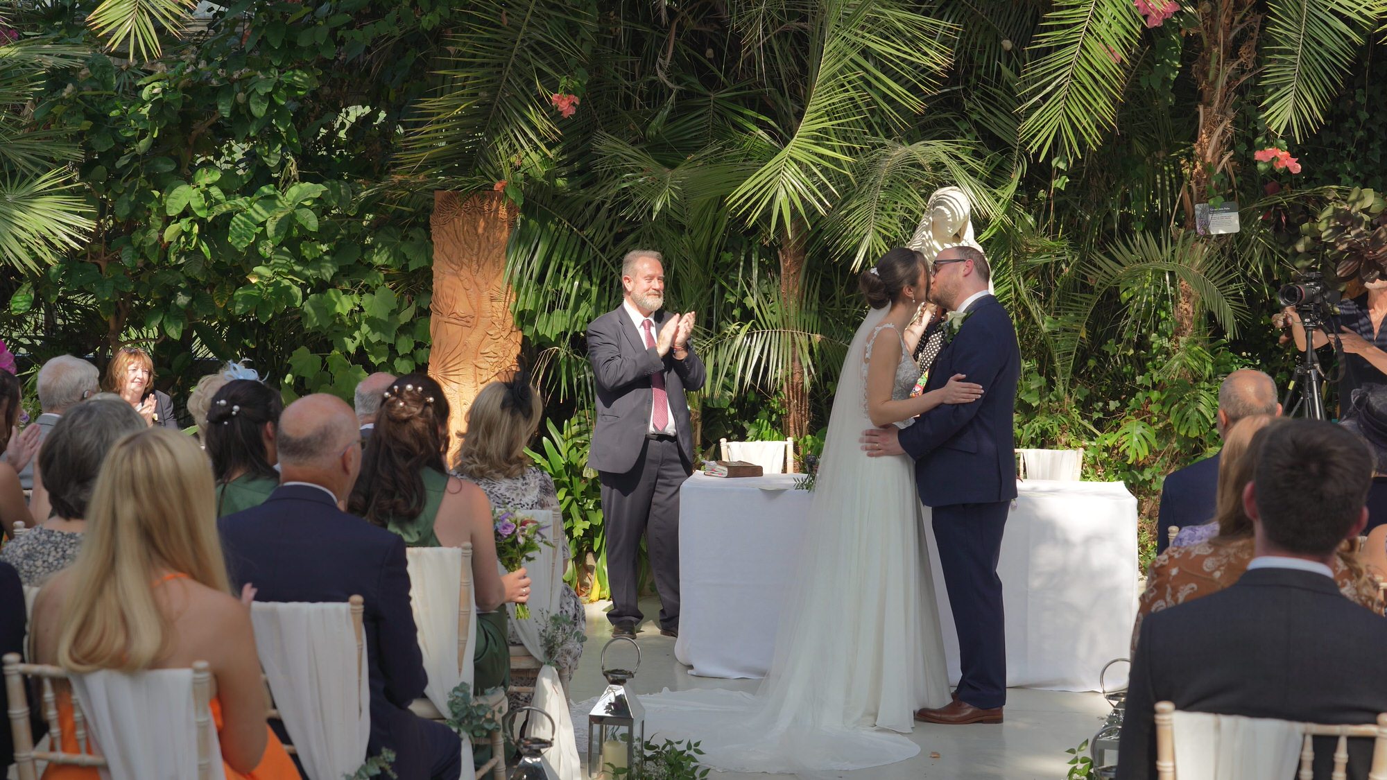 a couple kiss during ceremony at Sefton Park Palm House