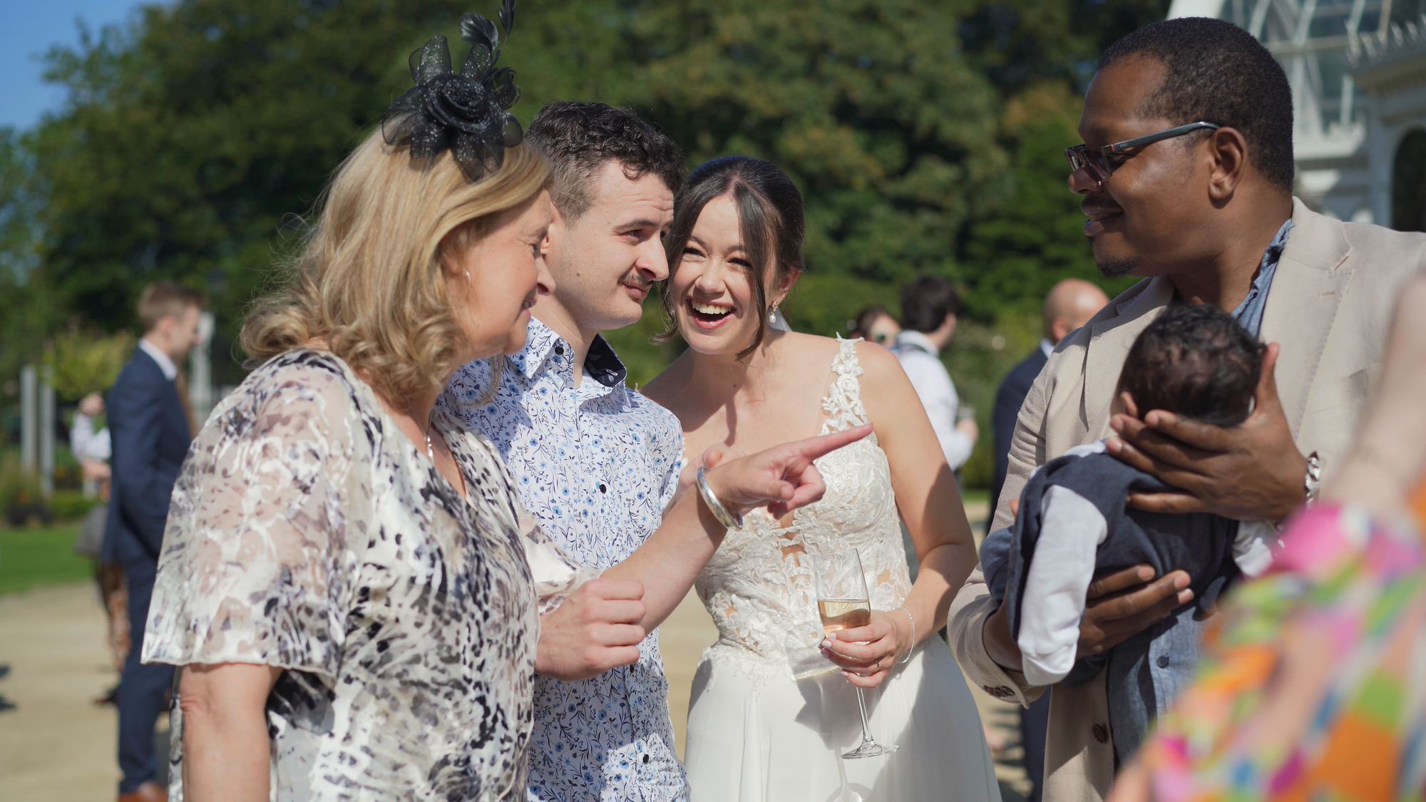 guests smile at a newborn baby during wedding reception