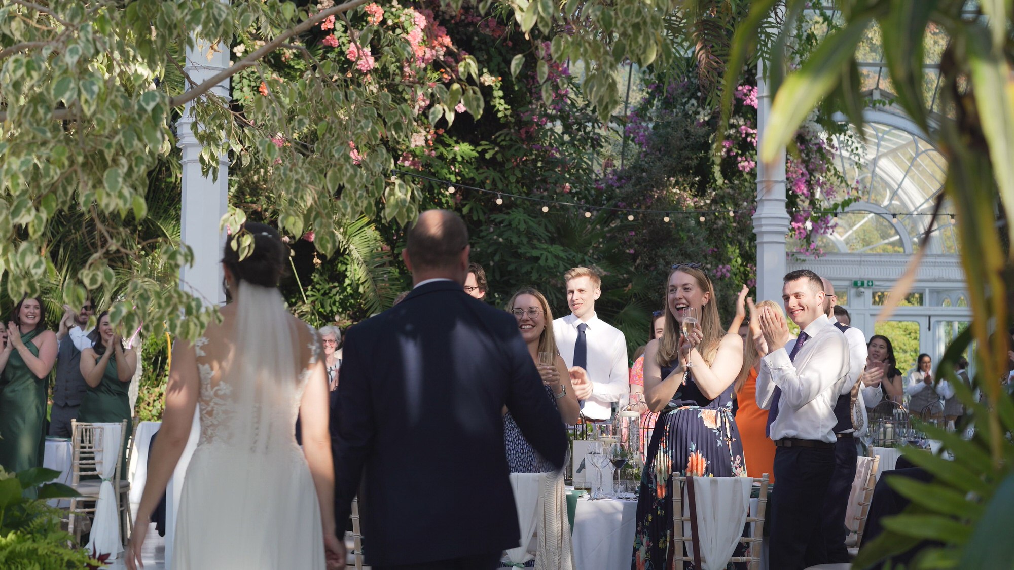 a couple walk in to their wedding breakfast at Sefton Park Palm House Liverpool
