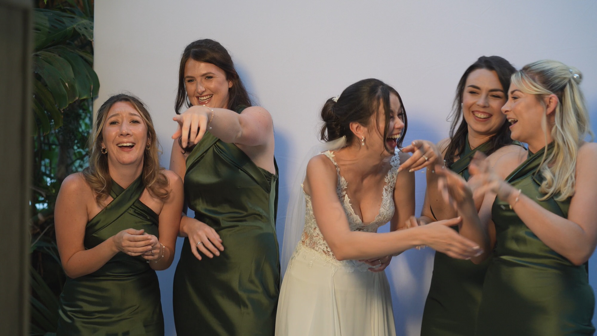 a bride laughs with her bridemaids at a silly photobooth photo