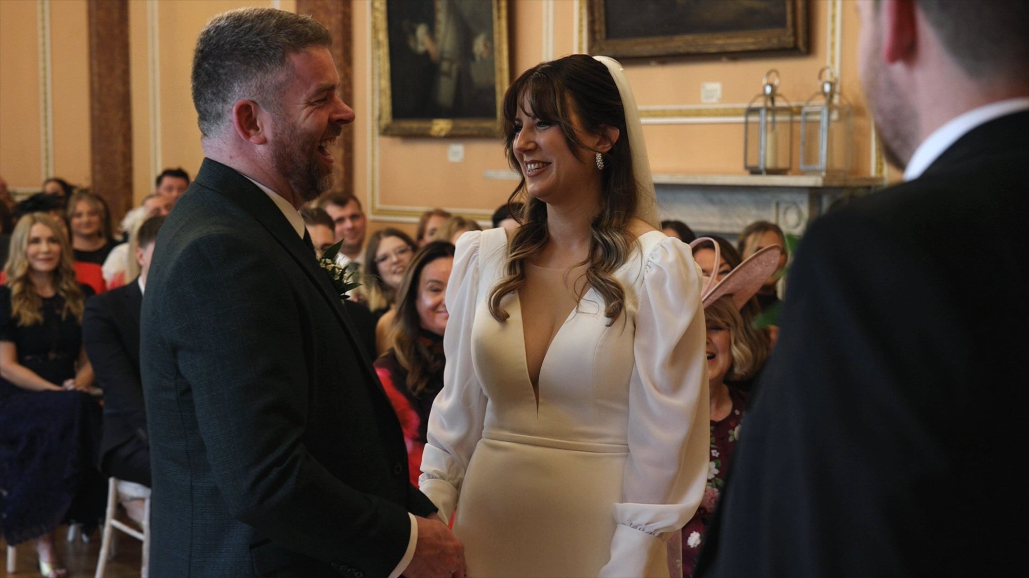 candid video moment of a couple laughing during their town hall wedding ceremony