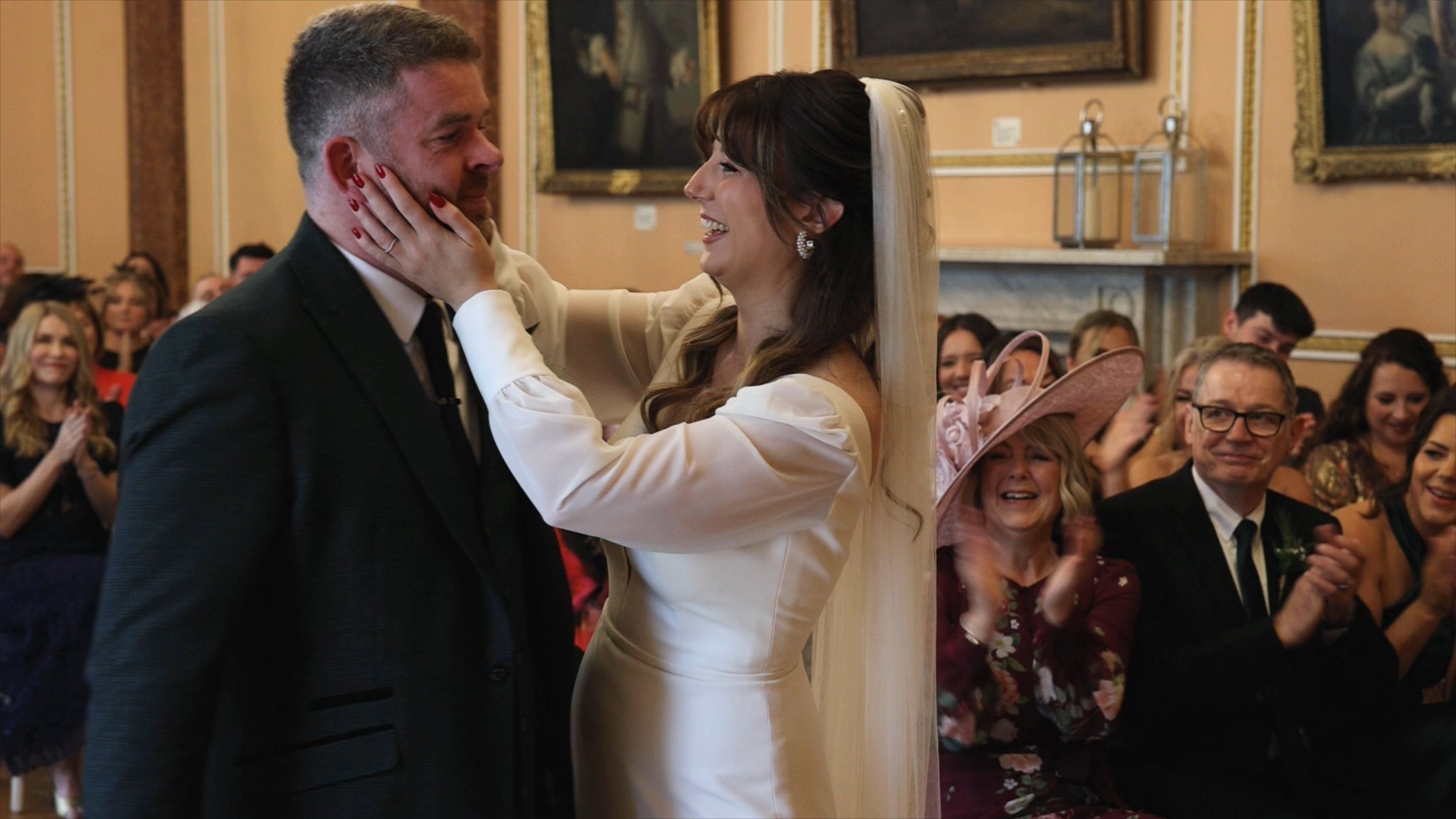 a candid moment of a bride wiping away a grooms tears during ceremony