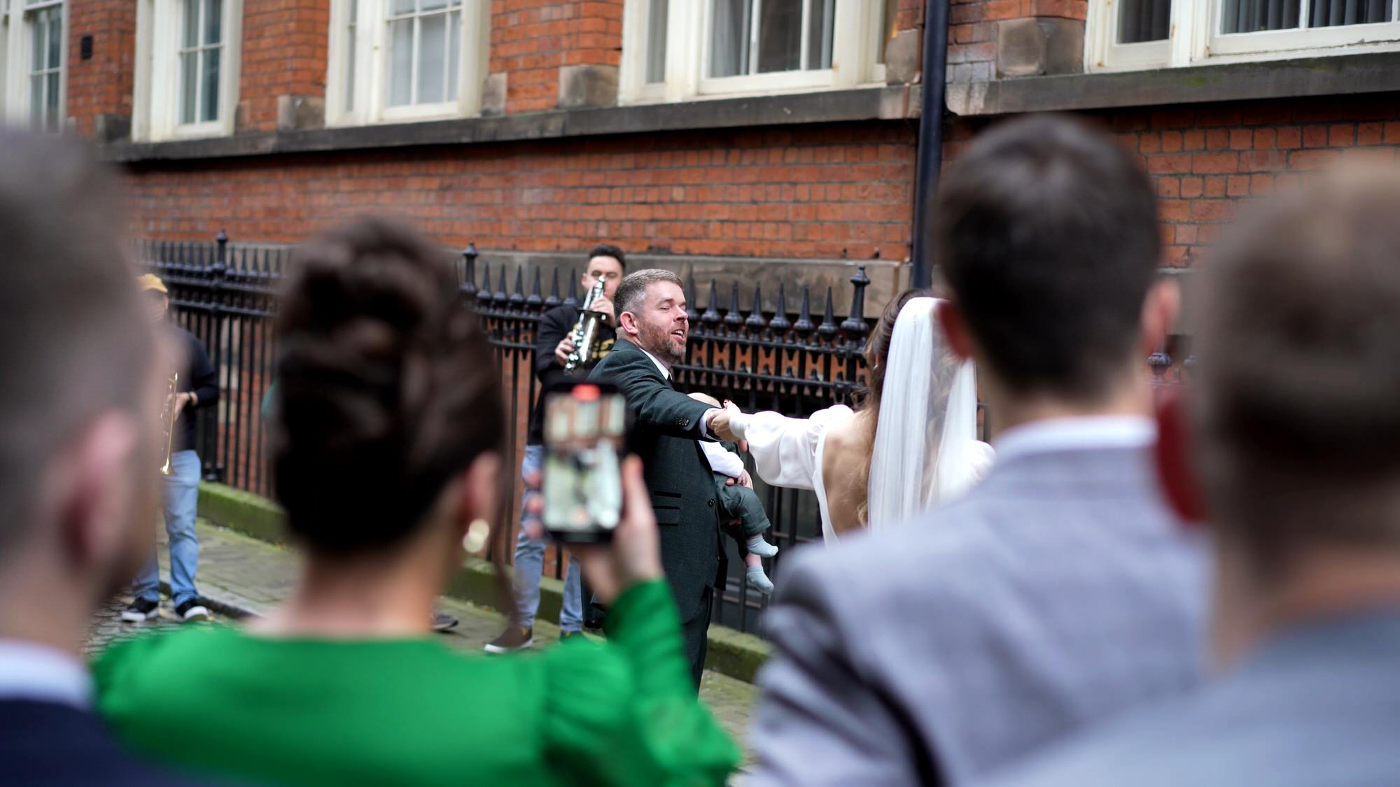 a video shooting through guests to capture couple dancing