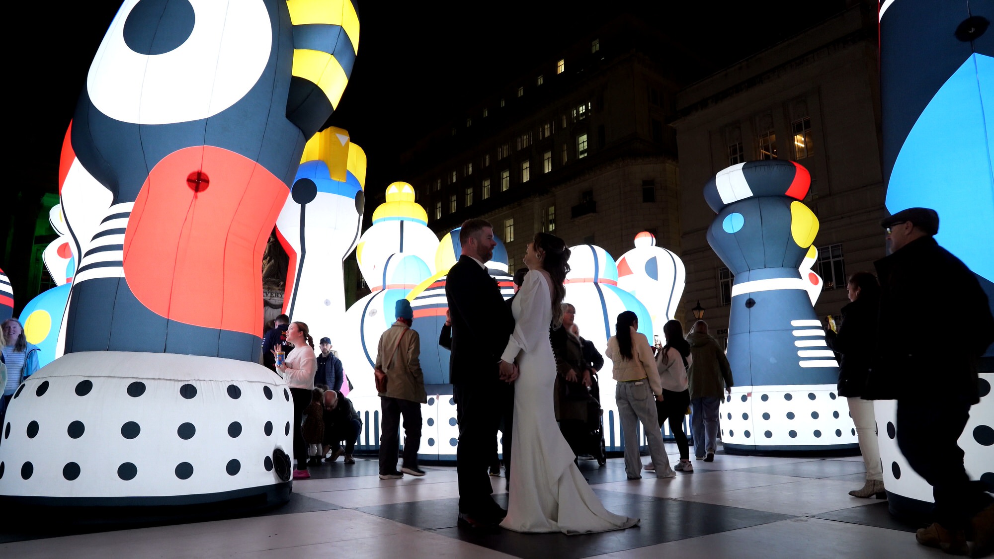 couple laugh for videography filming them at a River of Light festival installation in Liverpool