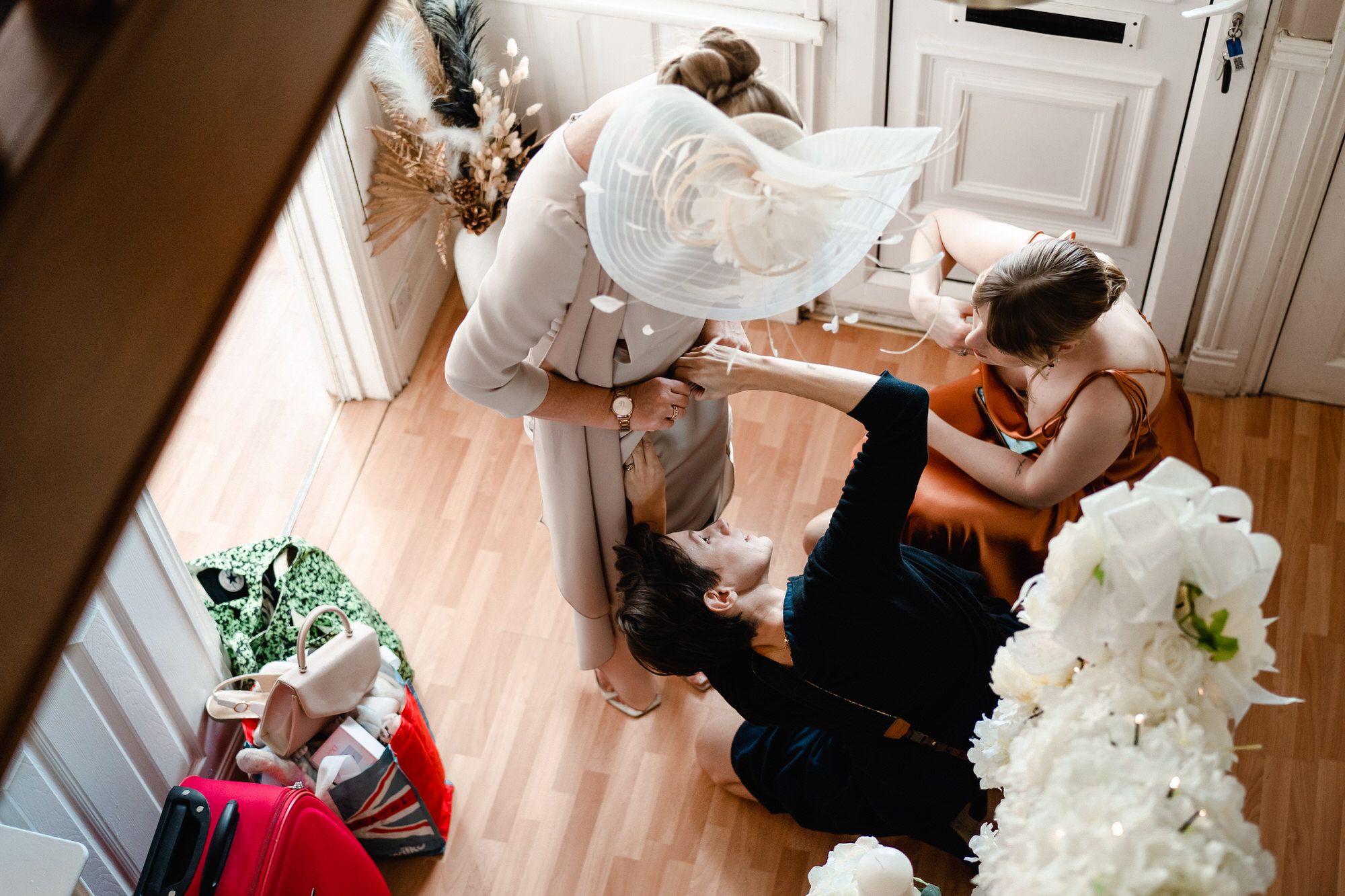 female videographer helps mother of the bride with her dress
