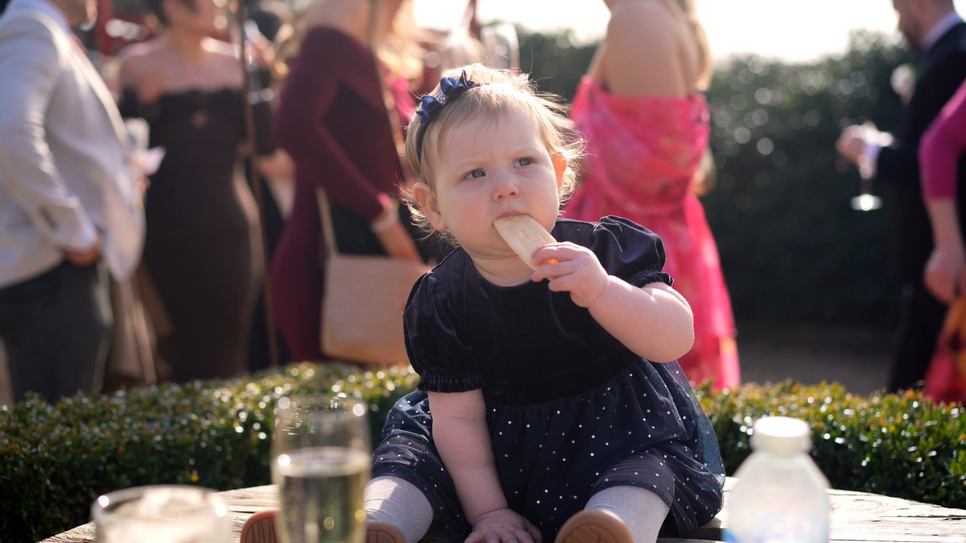 a toddler guests enjoys some snacks at a wedding