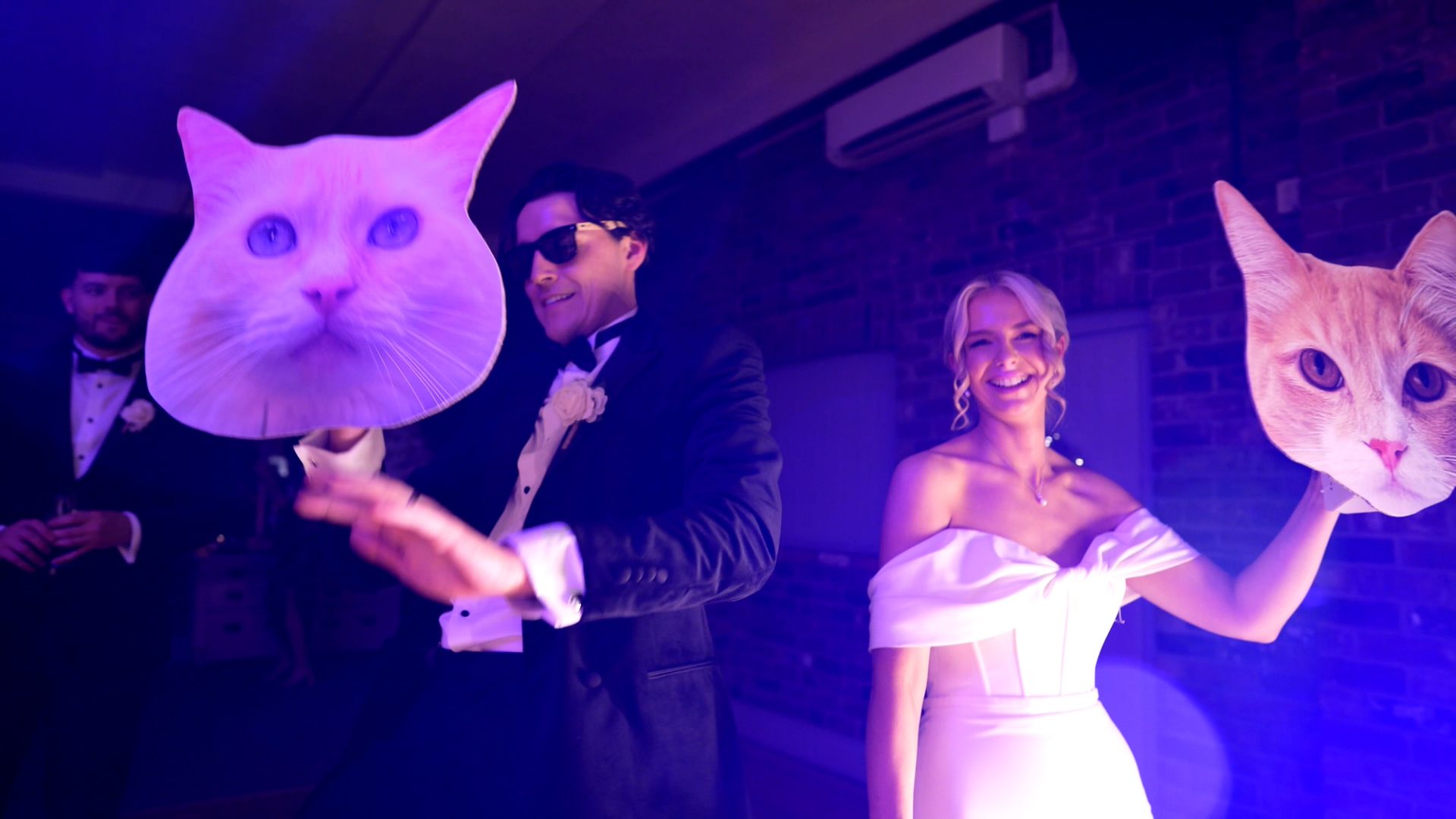 the couple dance with large masks of their cats at their Larkspur Lodge wedding